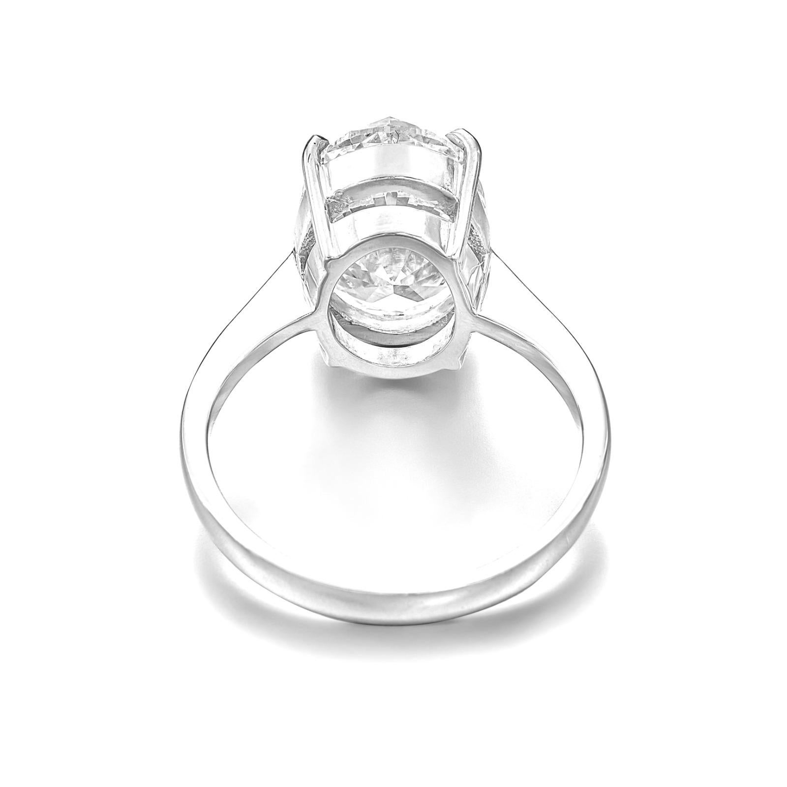 Crafted with meticulous attention to detail, this 18K White Gold Ring is the epitome of classic elegance. It features a stunning 5.03 carat oval cut diamond, which radiates sophistication. 

With a rare gem, this D colored diamond sparkles with