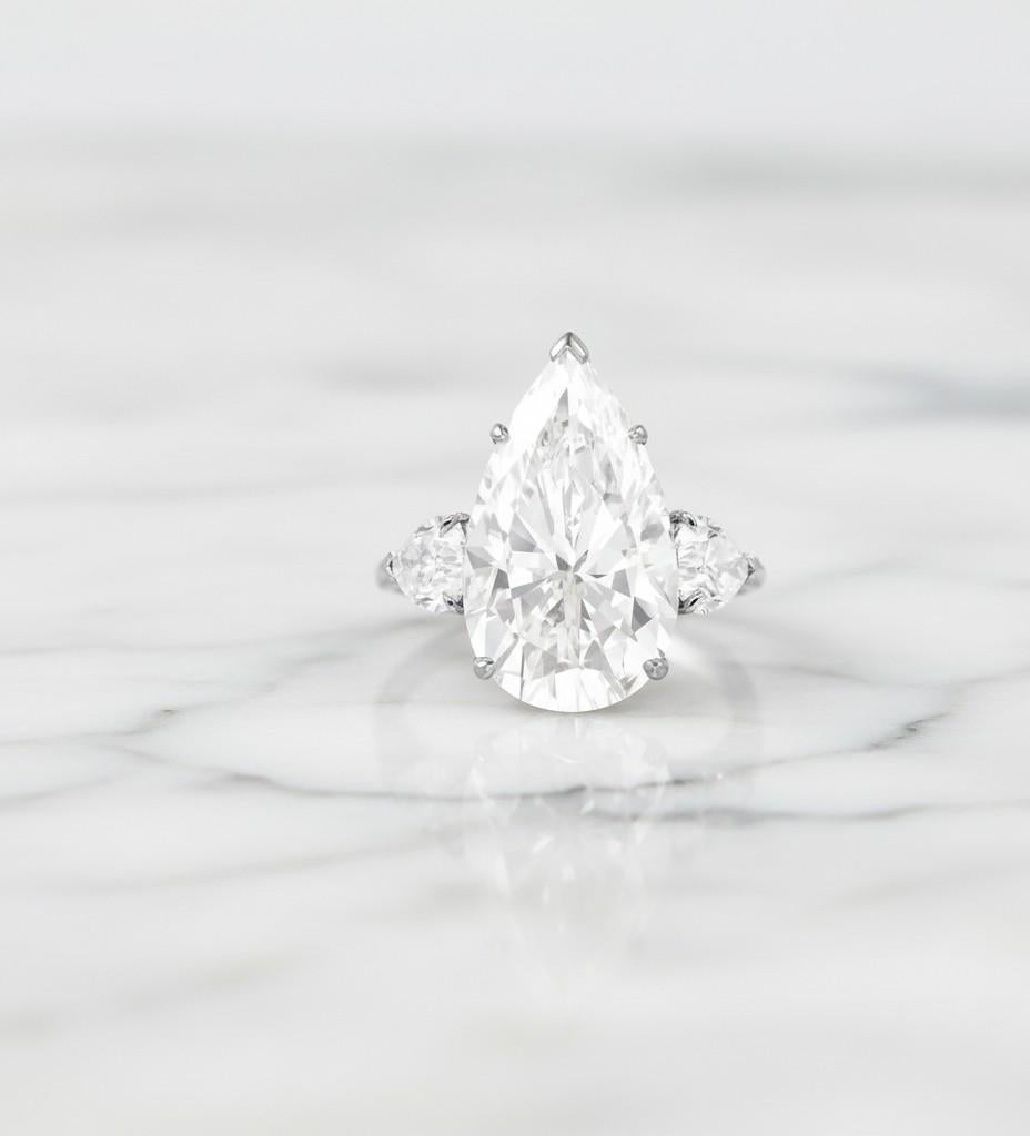 Atemberaubender Typ 2A Golconda GIA-zertifizierter Diamantring mit 7,02 Karat im Birnenschliff, sorgfältig in luxuriöses Platin gefasst. Jeder der seitlichen Diamanten weist eine Reinheit von VVS und eine Farbe von D auf, was eine außergewöhnliche