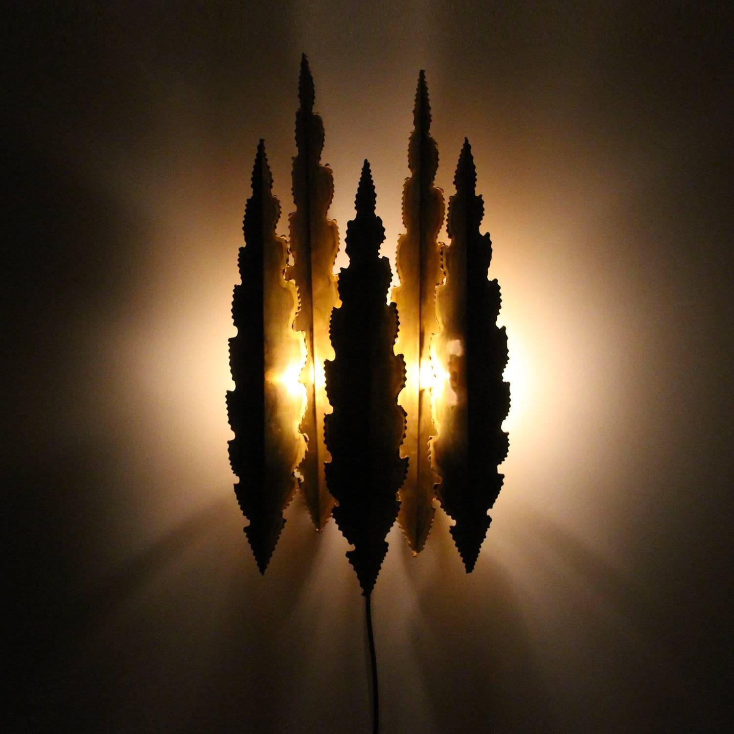 Type 5195, large brass wall sconce from the 1960s by Svend Aage Holm Sorensen, rare large Brutalist style wall light in excellent vintage condition.

A beautiful large wall light comprised of five serrated and flame-treated brass pieces, each