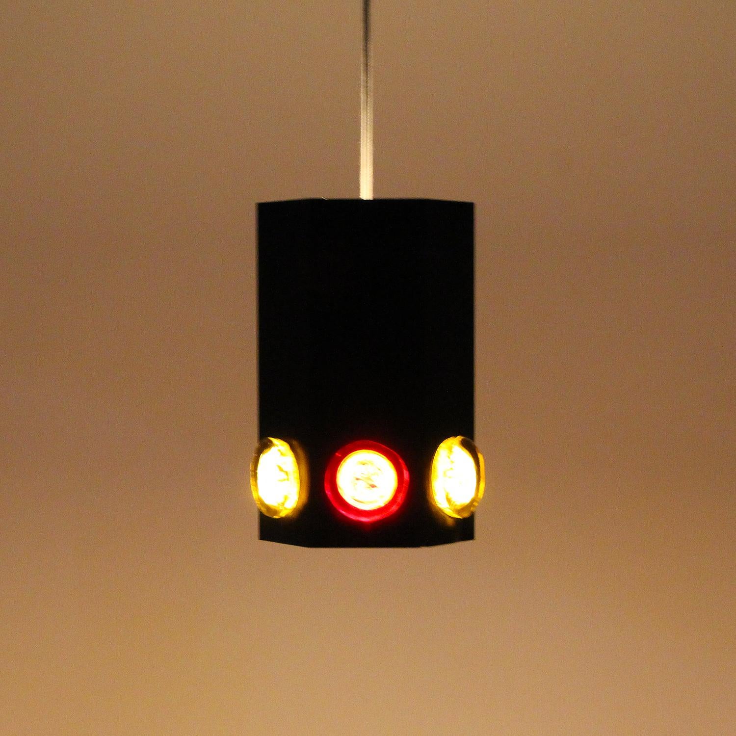 TYPE 6284, black pendant by Svend Aage Holm Sørensen in the 1960s - intriguing rare black lamp with yellow and red glass stones.

A hexagonal shaped metal pendant, lacquered black with white inner, and decorated with circular red and yellow glass