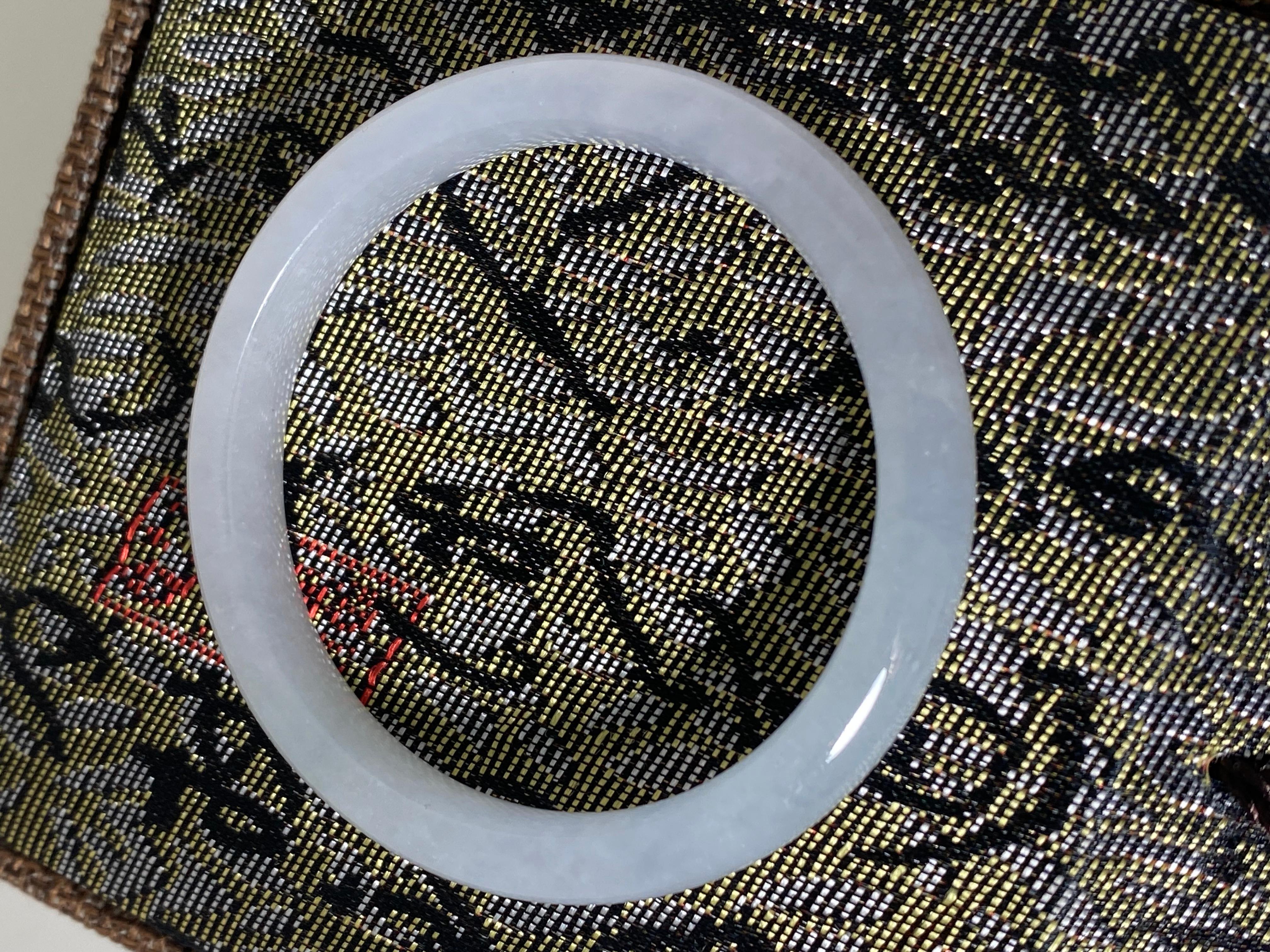 Natürlicher Typ A Jadeit Armreif 
von sehr gleichmäßiger (selten gesehener) grau-weißer Farbe 

Breite: 9mm  
Umfang: 18,5cm
Gesamtgewicht des Artikels: 24.6gr.
Innendurchmesser: 48 mm 
Äußerer Durchmesser: 60 mm 

Wird in einer Schachtel geliefert,