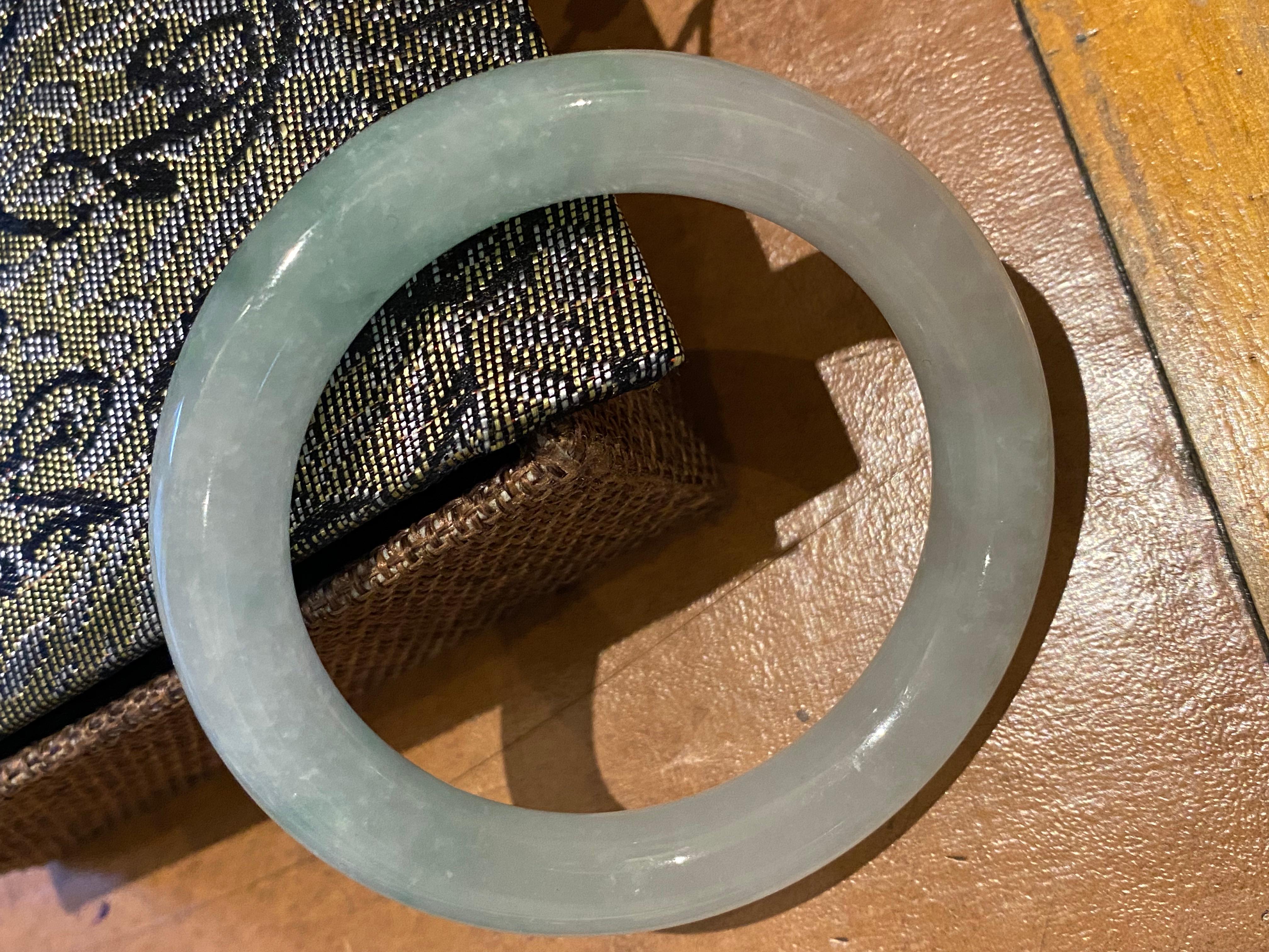Natural Type A Jadeite Bangle 
of greyish green colour 

Width: 12mm  
Circumference: 21cm
Total item’s weight: 59.7gr. 
Inner diameter: 55mm 
Outer diameter: 76mm 

Comes in a box, 
Accompanied by valuation certificate