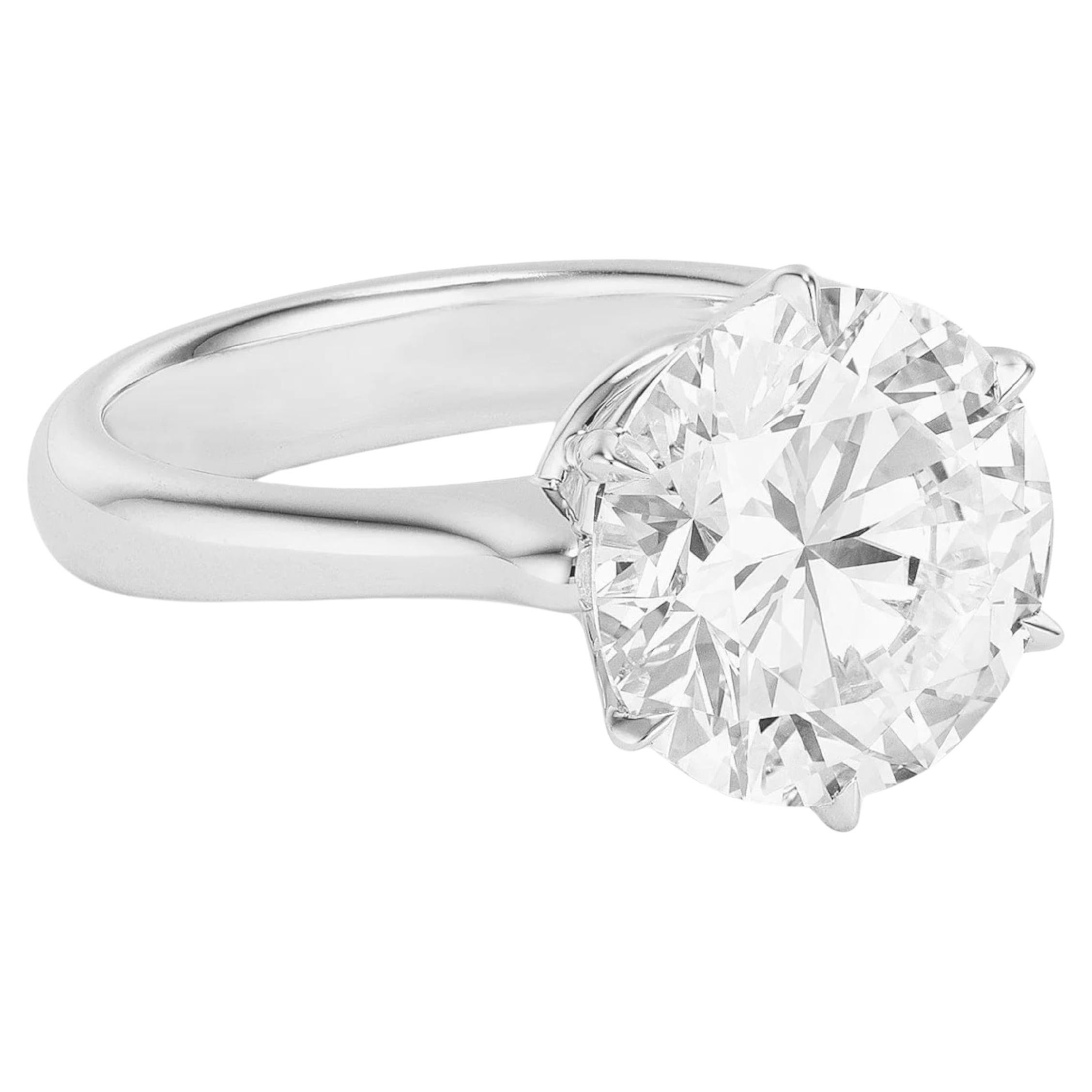 This exceptional GIA Certified solitaire ring features a breathtaking 5.70 Carat round Cut diamond, offering timeless beauty in its purest form. 
Set in 18K white gold, the design showcases the diamond’s brilliance with classic elegance and minimal
