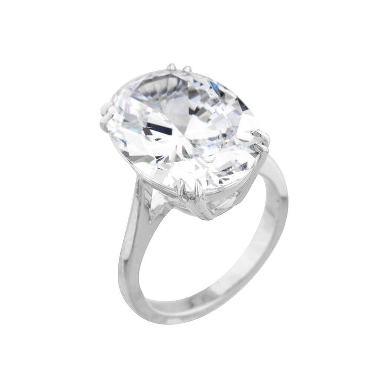 This exquisite engagement ring showcases a GIA certified 6.09 carat oval-cut diamond, elegantly set in a sleek 18K white gold band. The elongated shape of the oval cut enhances the diamond’s brilliance while creating a flattering, elongating effect