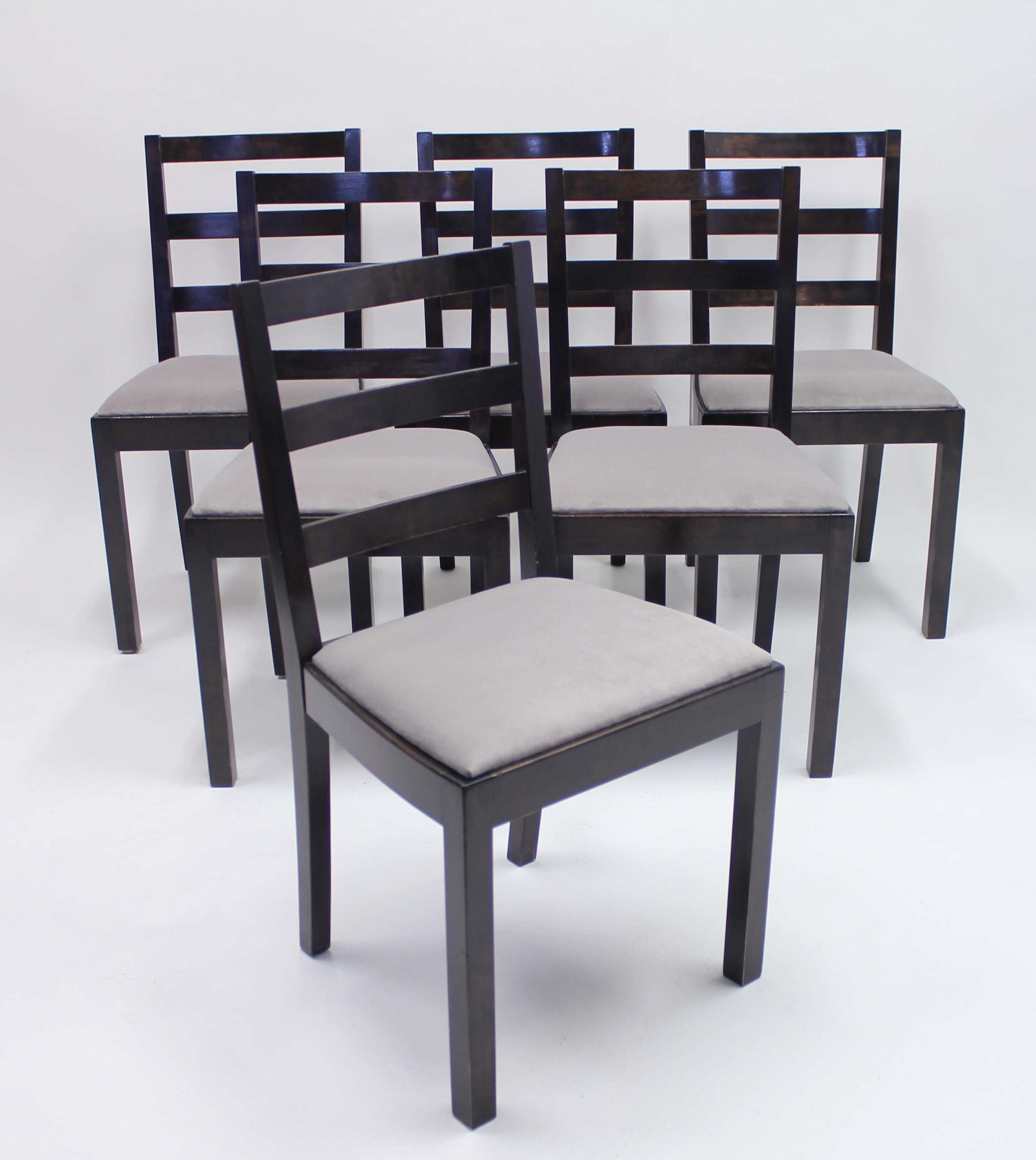 Set of six Typenko chairs designed by Axel Einar Hjorth in 1931 for Nordiska Kompaniet. Frame of dark stained birch with new light grey velvet upholstery. All of the chairs have the original metal plack from the manufacturer. The present model is
