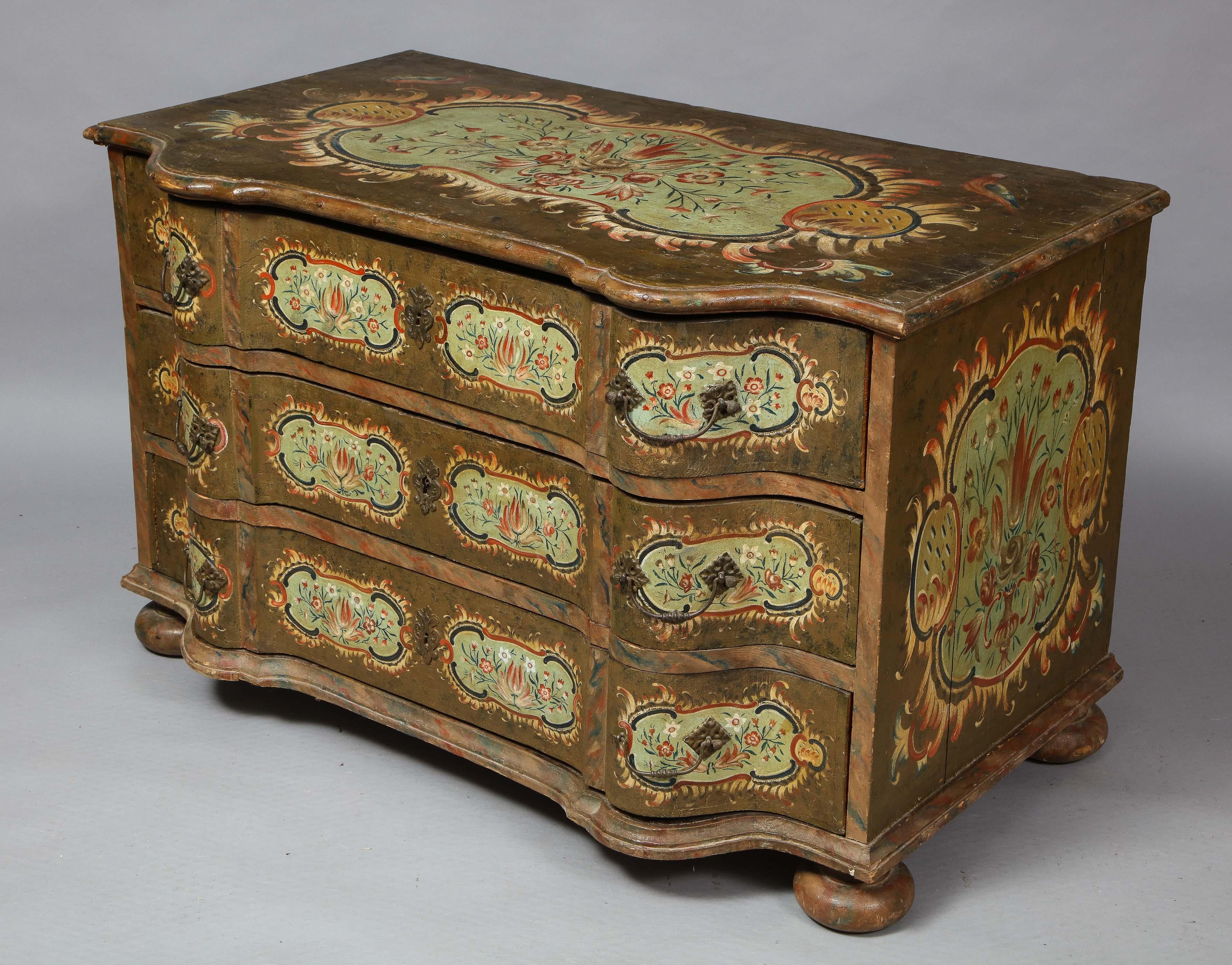 Very fine 18th century painted three drawer commode of baroque form, the top with foliate painting within a rococo cartouche surmounted with birds, over three drawers each with four similarly decorated panels and having original wrought iron