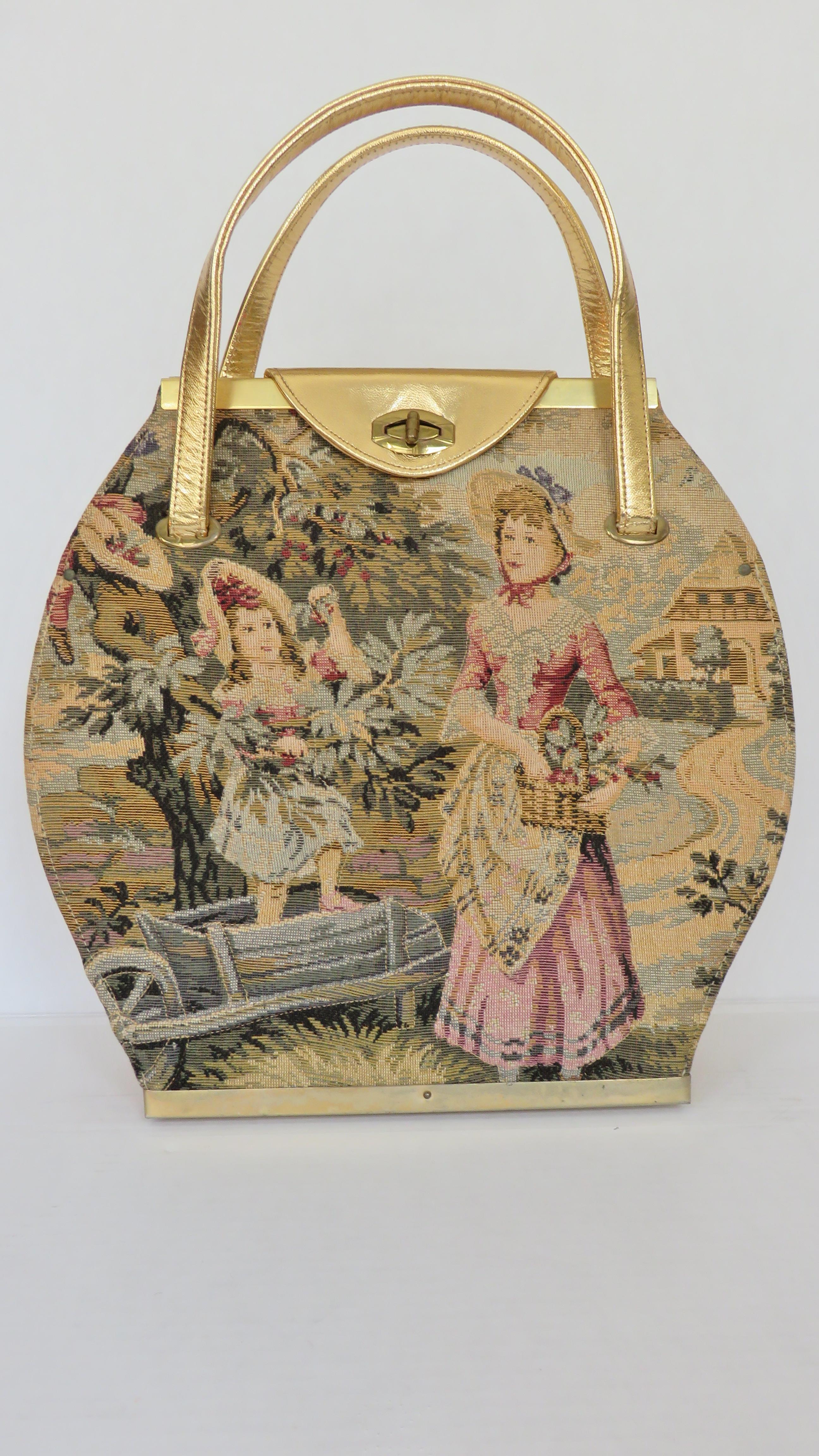 A unique rounded shape gold and tapestry handbag from Tyrolean.  It has double top handles and a gold turn lock closure on a gold flap. The top and bottom are framed in gold metal.  The front is an 18th century tapestry scene of a woman and child