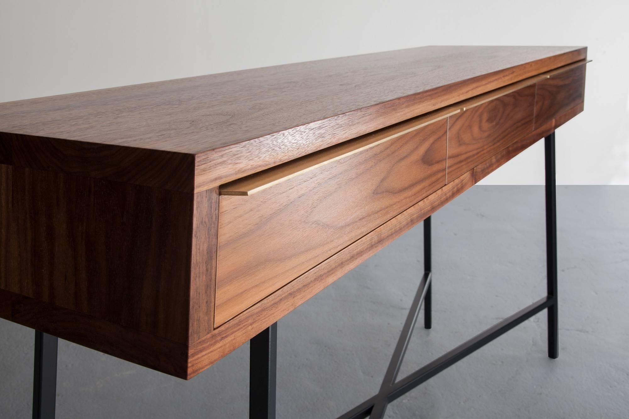 The Tzoid console is a walnut hardwood case sitting atop a black / grey powder coated steel frame complete with brass pulls. Shown in walnut and available in ash, maple, and white oak. Powder coated frame is shown in black grey and also available in