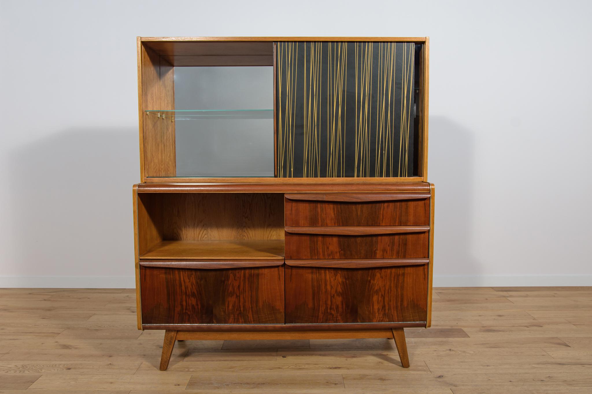 Thi cabinet, Model U-372/386, was designed by Bohumil Landsman and Hubert Nepožitek for Jitona and produced in the 1960s. The cabinet is made of walnut and oak veneers, with interesting graining. Beech wood legs. The cabinet is finished with metal