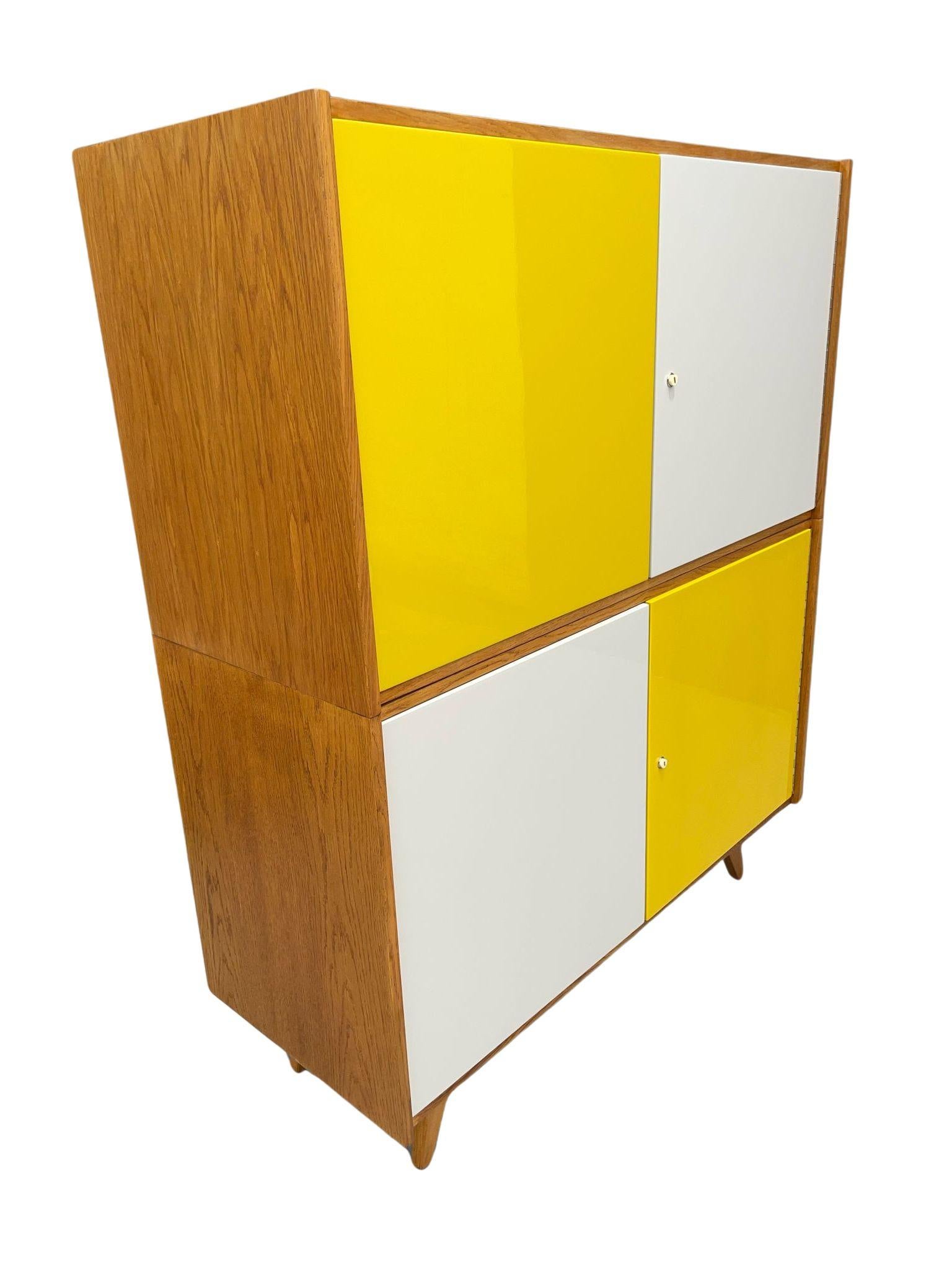This cabinet is part of the iconic U-450 series designed by Jiří Jiroutek during his collaboration with the state company Interiér Praha. This particular piece is confirmed by the original production label from the Třešť plant, marked as U-450