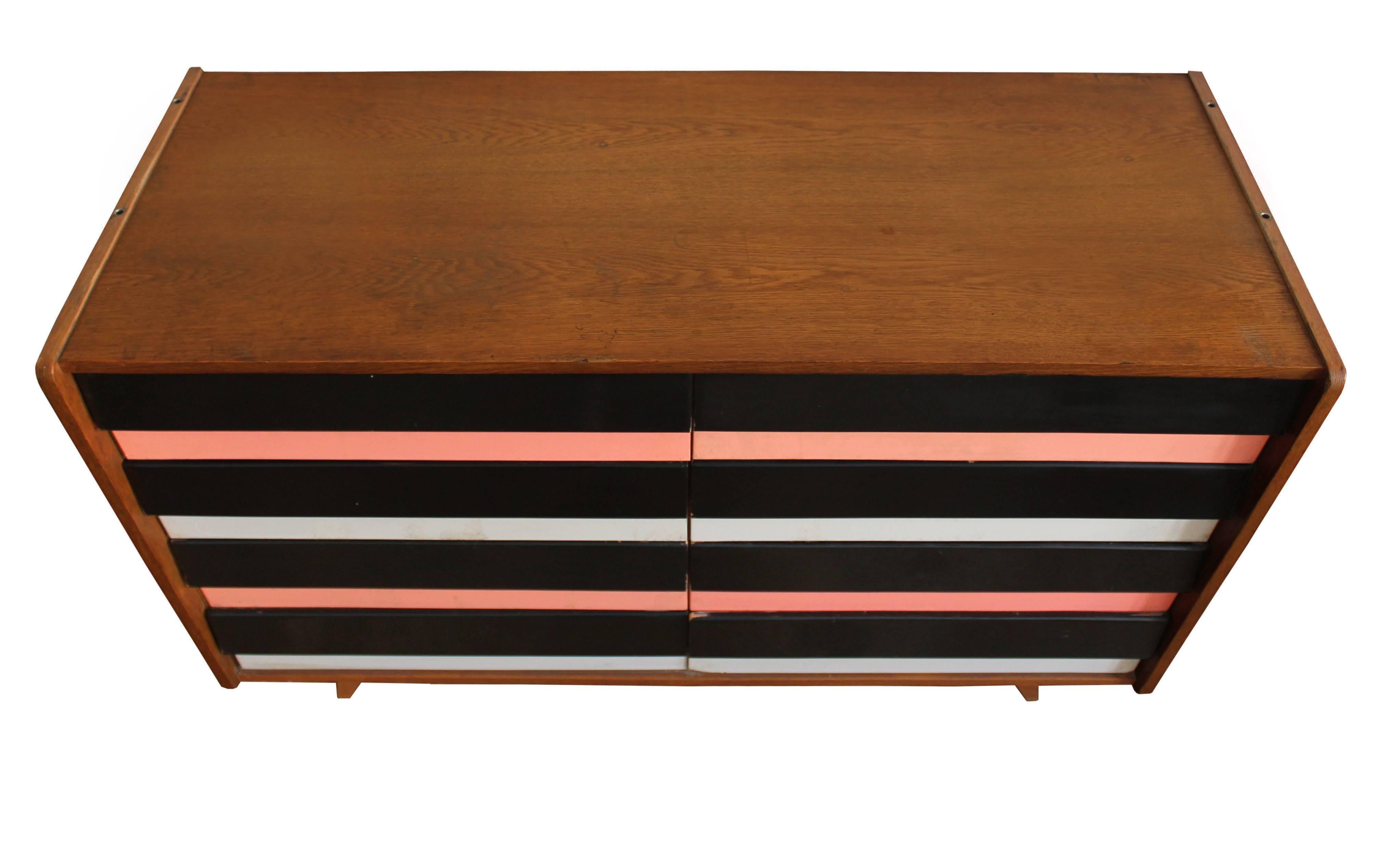 The U-453 sideboard with black, pink and white Formica drawers, was designed by legendary Czech furniture designer Jiri Jiroutek, and was part of the popular U collection manufactured by Interier Praha in the 1960s Czechoslovakia. This piece