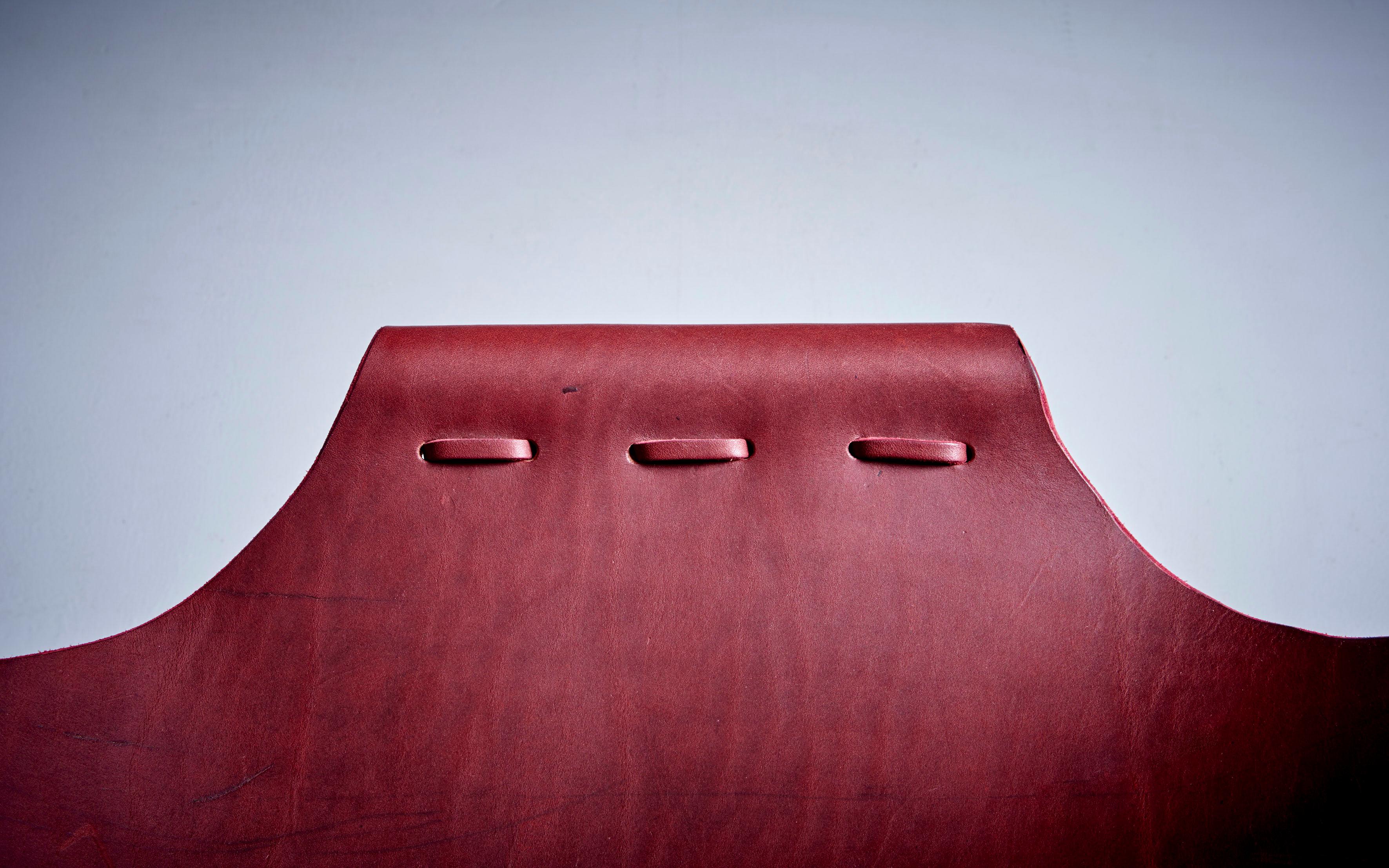 A unique chair for reading and lounging. Rest your back against one side and your legs against the opposite side. Latigo leather and powder-coated steel frame. The leather can be chosen in black, cognac, red and dark brown. Frame is lacquered in