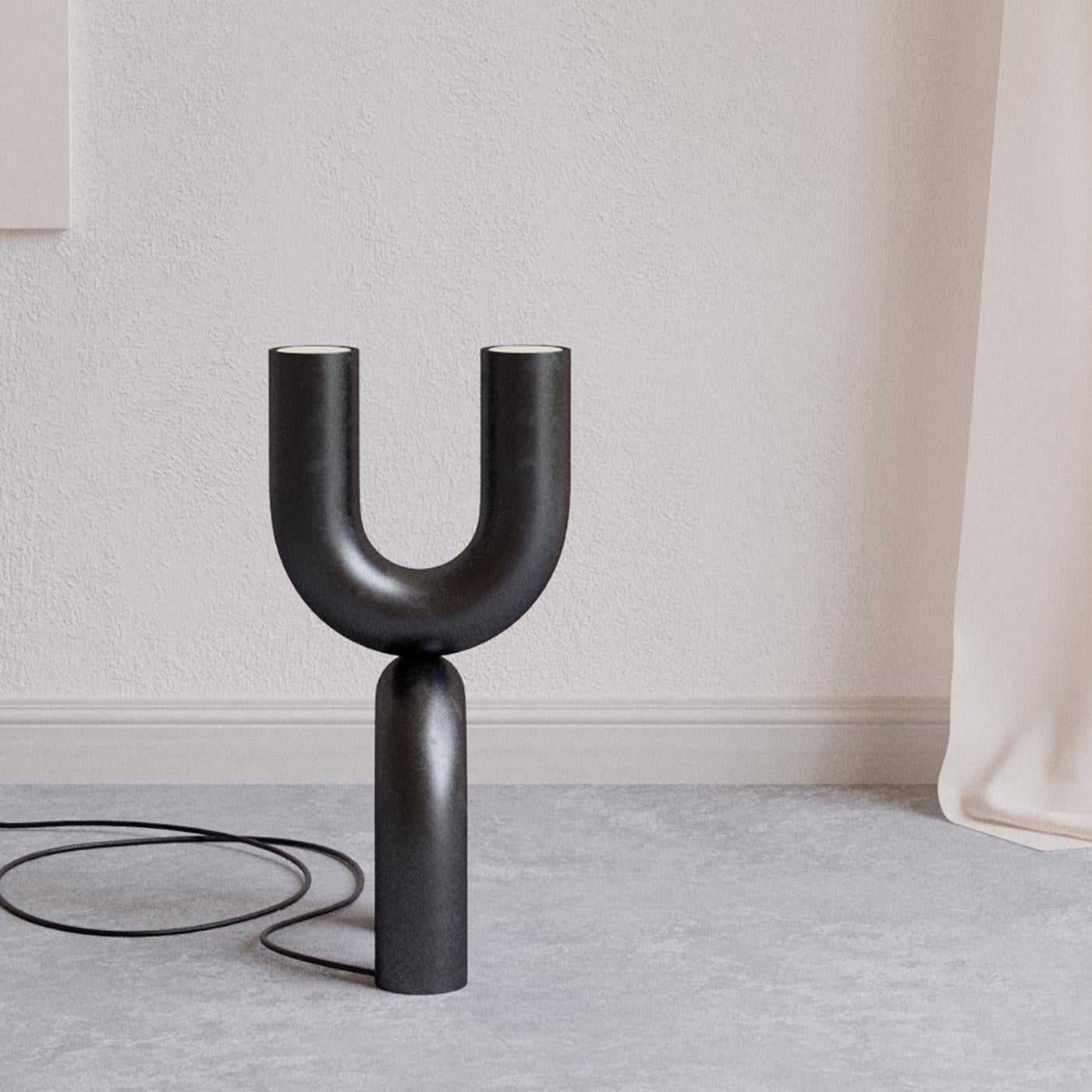 A totemic design obtained by piling two Us facing opposite directions, this stunning floor lamp will provide illumination while adding an exquisite artistic twist to corners of contemporary homes. The steel frame features a homogeneous black finish