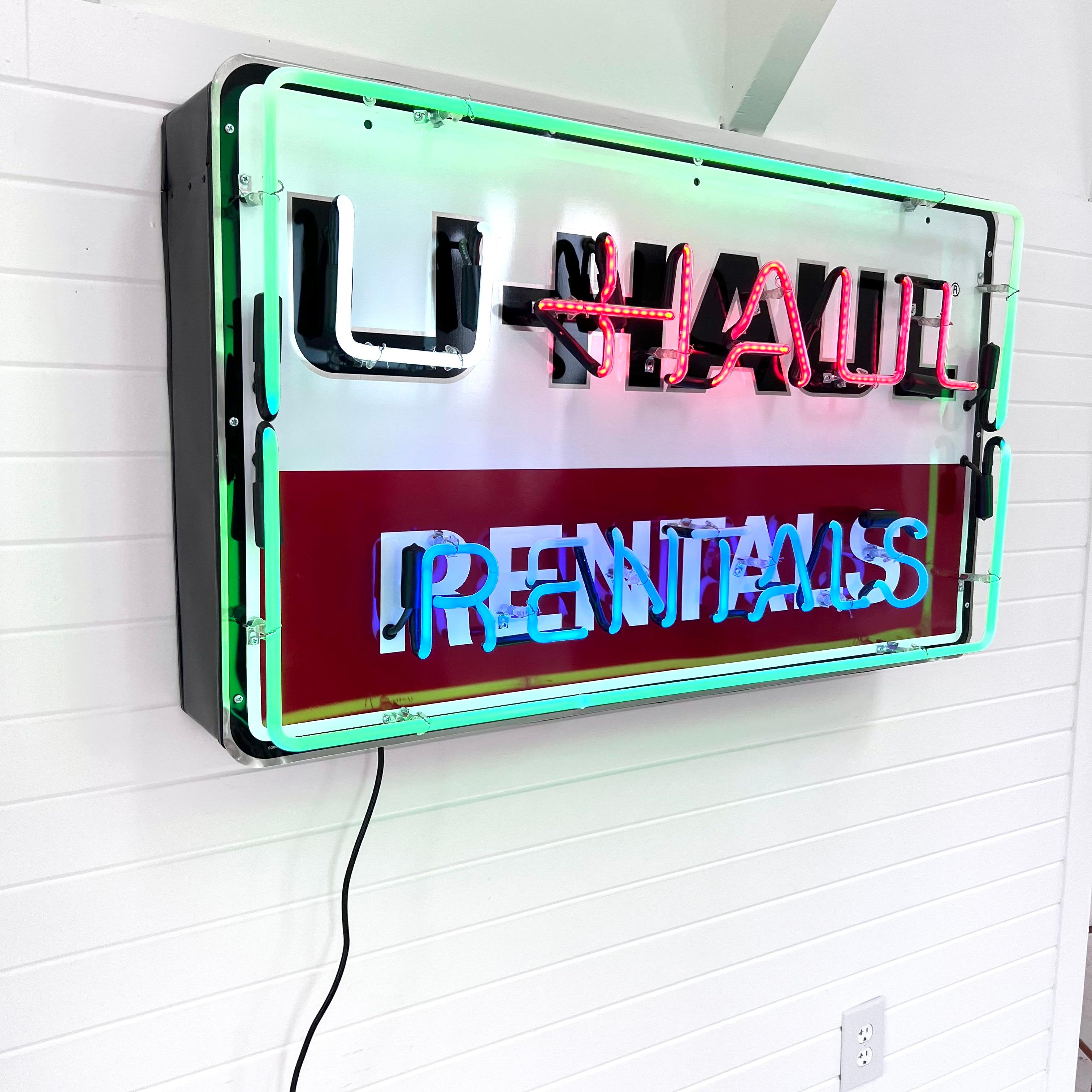 Vintage U-haul sign with newly added neon. U-haul company name against background of white over orange and four different colors of neon. High gloss shine with UV protection. Brand new neon glass, transformer and GTO wiring on a die-cut metal can