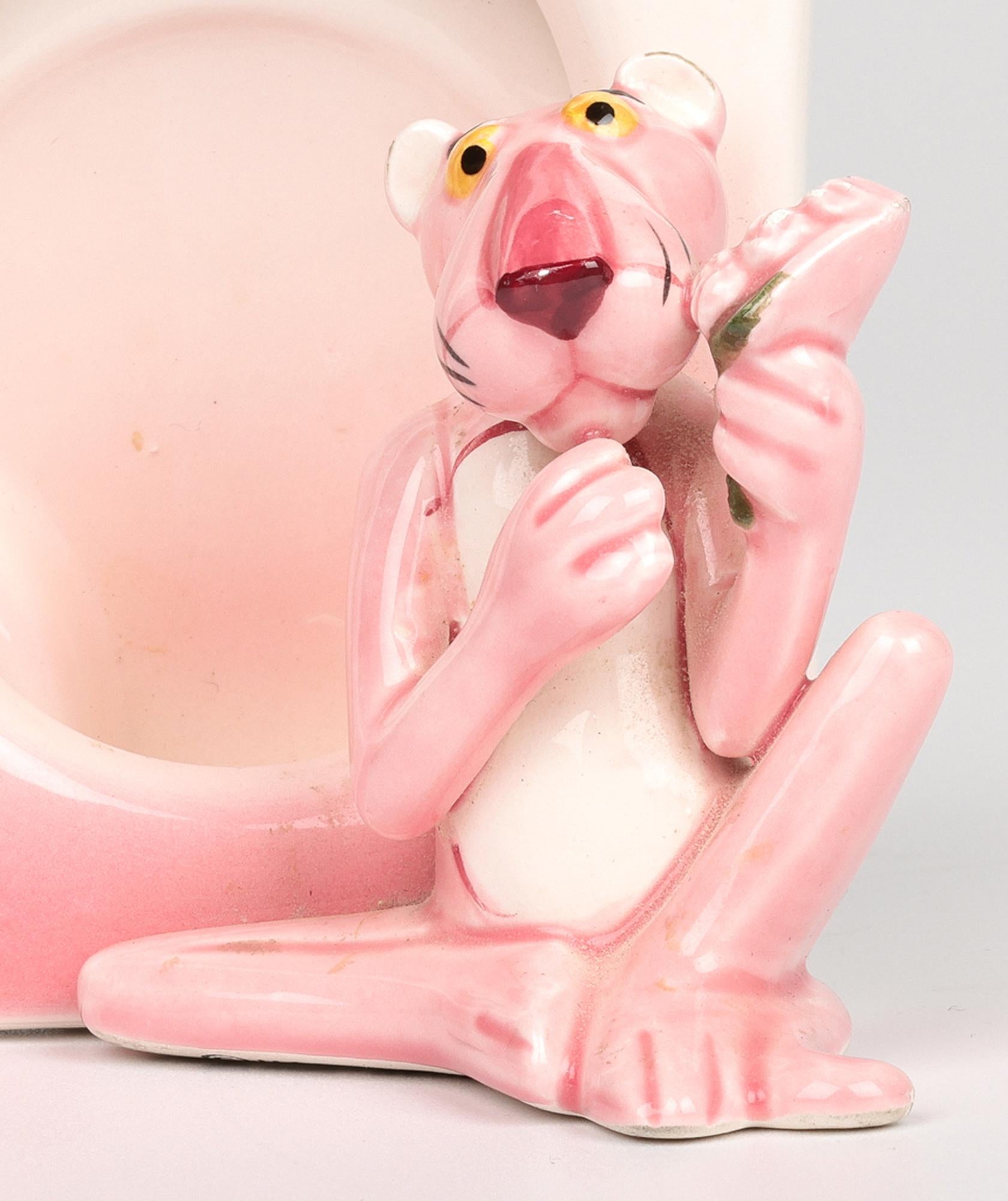 Un delicioso portarretratos vintage japonés UAC Geoffrey de cerámica de la Pantera Rosa producido bajo licencia de United Artists y que data de alrededor de 1981. El marco de cerámica es de forma rectangular pequeña con una abertura ovalada a la que