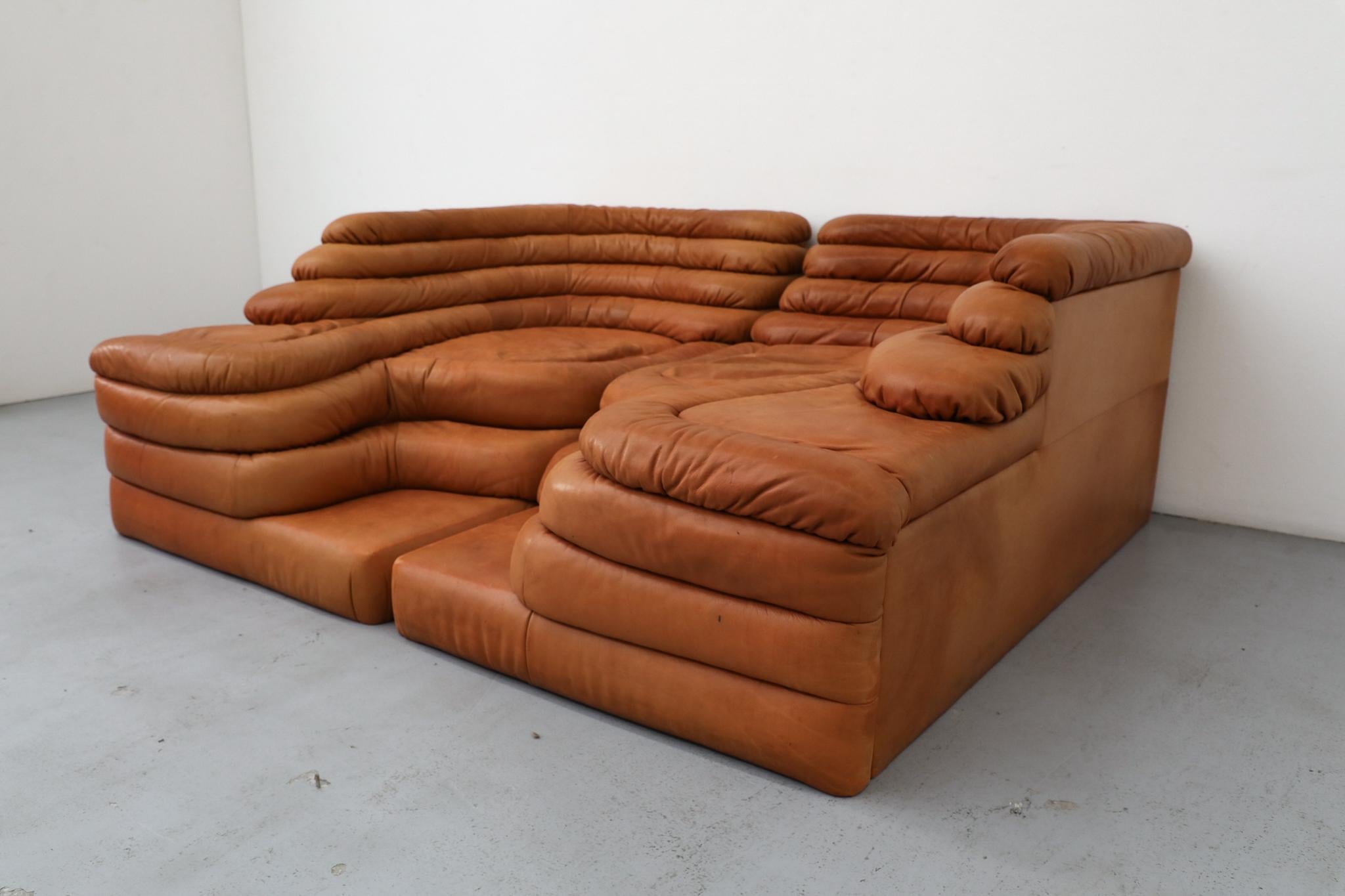 Il divano DS-1025 'Terrazza', un paesaggio di sedute davvero iconico e distintivo, è stato progettato dal creativo svizzero Ubald Klug nel 1973 per il produttore di pelli di lusso De Sede. Presentato qui come set di due pezzi in una ricca e calda