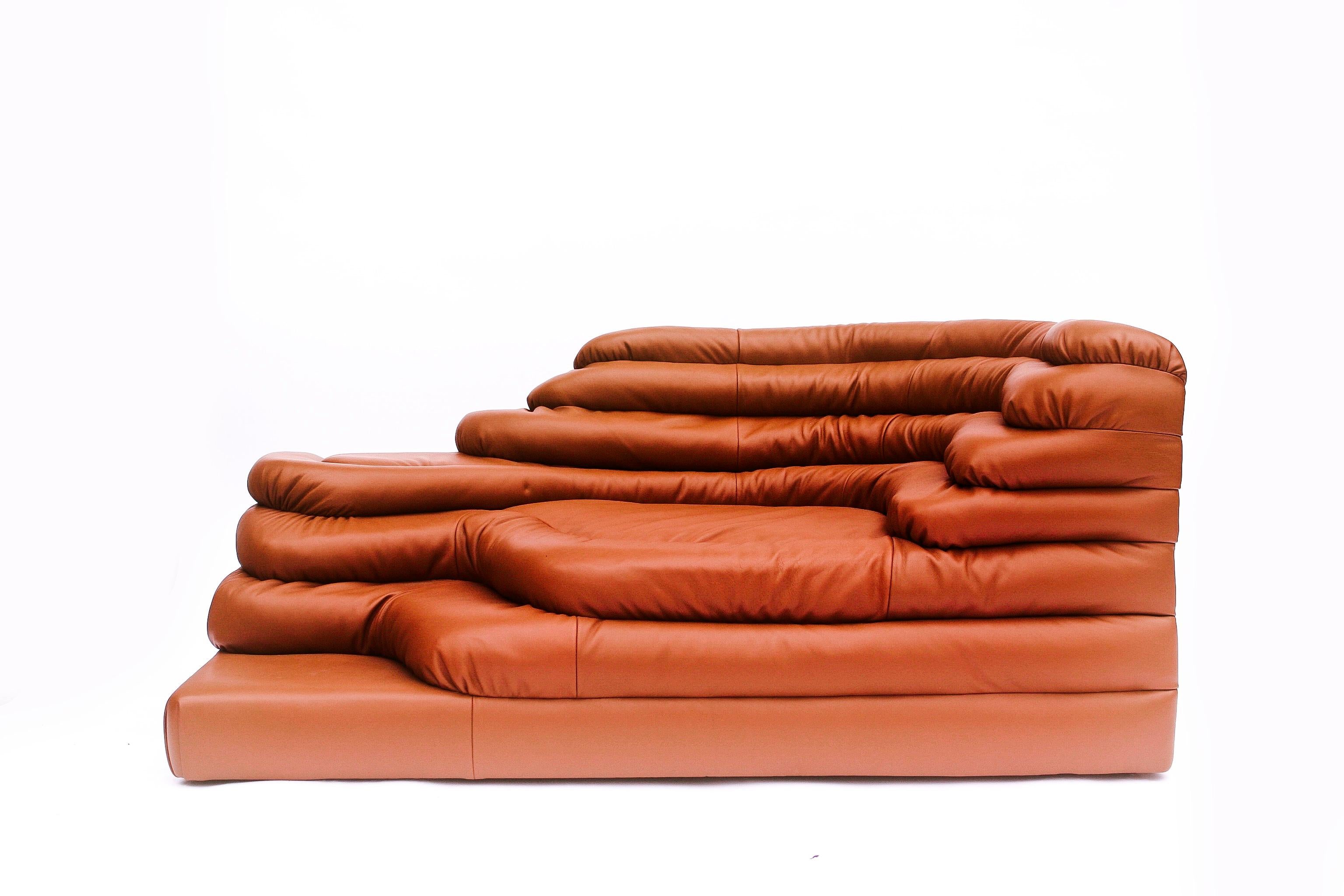 Le canapé Terrazza (1973) d'Ubald Klug pour De Sede est une expression emblématique du design des années 1970, alliant forme organique et artisanat luxueux. Inspirée par les contours stratifiés des paysages vallonnés, sa silhouette sculpturale est
