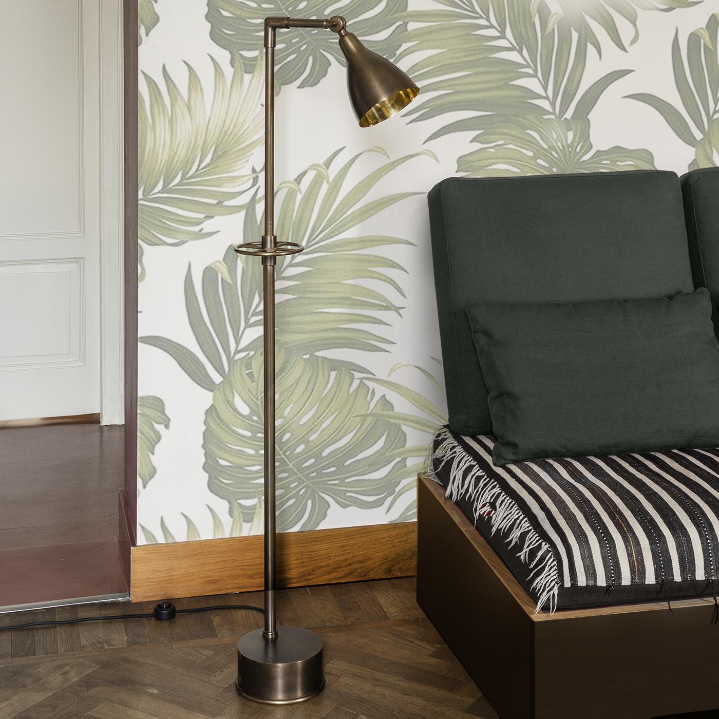 A perfect example of simplicity meeting functionality, this midcentury floor lamp has a solid burnished brass structure with a satin finish and a bell-shaped shade with a natural-finished interior that diffuses a warm, ambient light. Stretching out