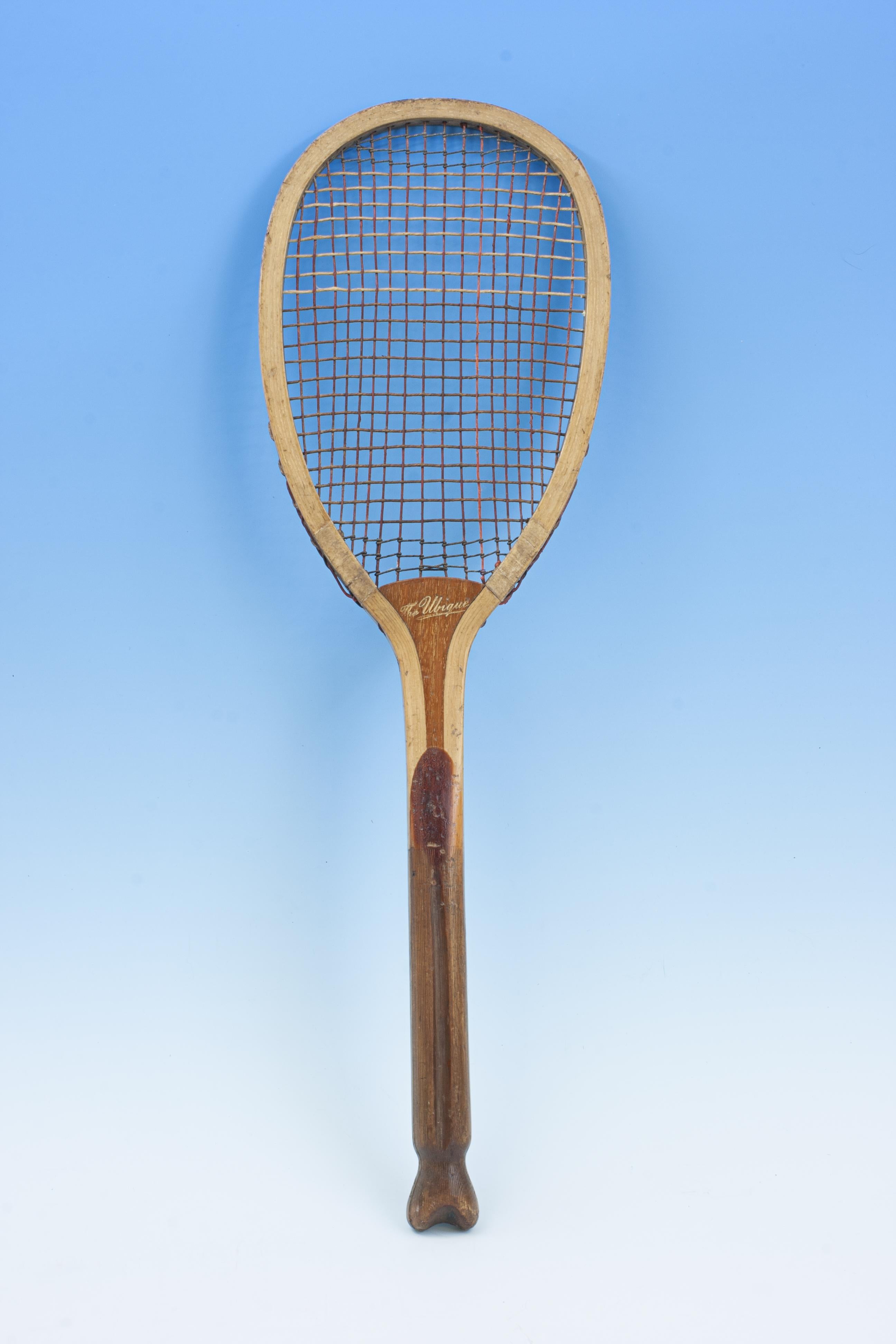 The Ubique Fishtail Lawn Tennis Racket.
A wooden lawn tennis racket with nice oval head, ash frame with convex walnut wedge, canvas wrappings on the shoulders. The wedge is embossed in gilt 'The Ubique. The handle with a deep central groove,