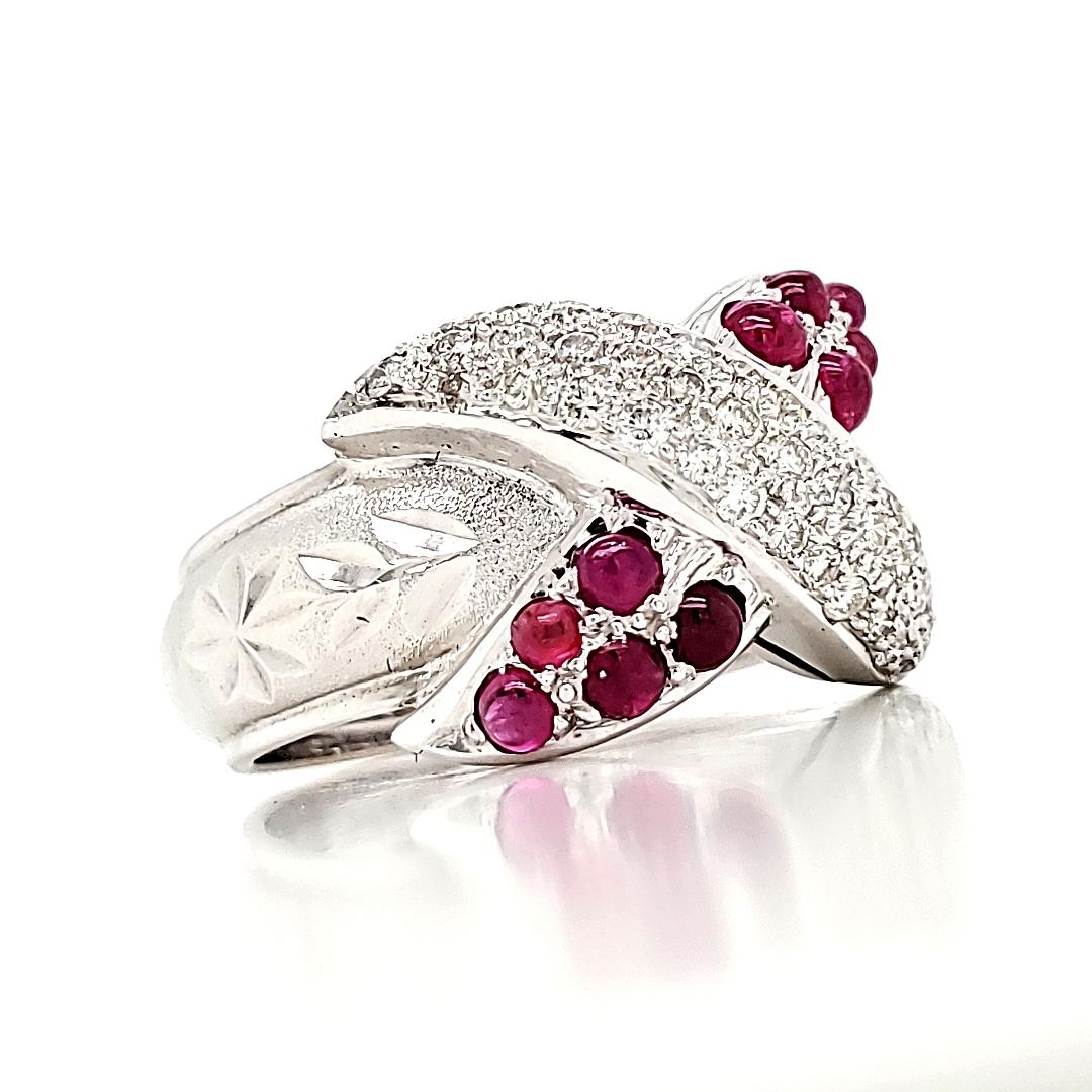 Crafted to elegantly wrap around your finger, this ring showcases mesmerizing overlapping lines adorned with 10 Ruby Cabochons, totaling 0.88 carats, and accentuated by 38 dazzling Round Diamonds, weighing 0.50 carats.

All set in 18 white gold,