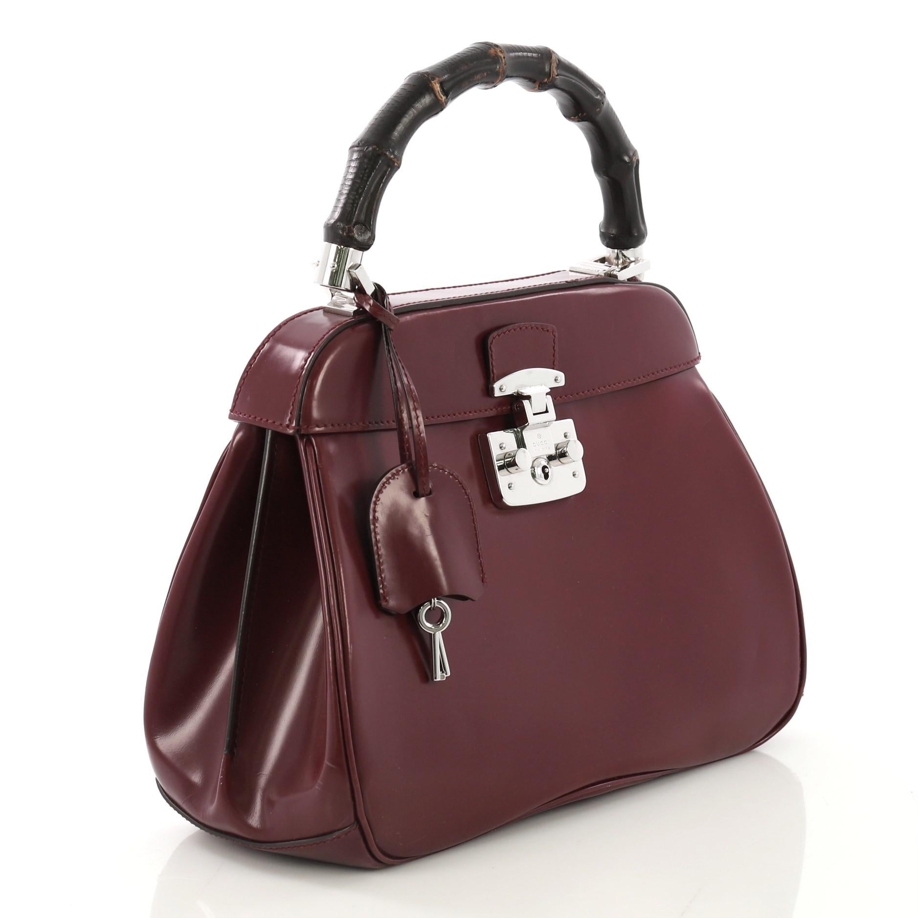 This Gucci Lady Lock Bamboo Top Handle Bag Leather Medium, crafted in purple leather, features a single loop bamboo handle and silver-tone hardware. Its flap with lady lock closure opens to a purple microfiber interior divided into two compartments