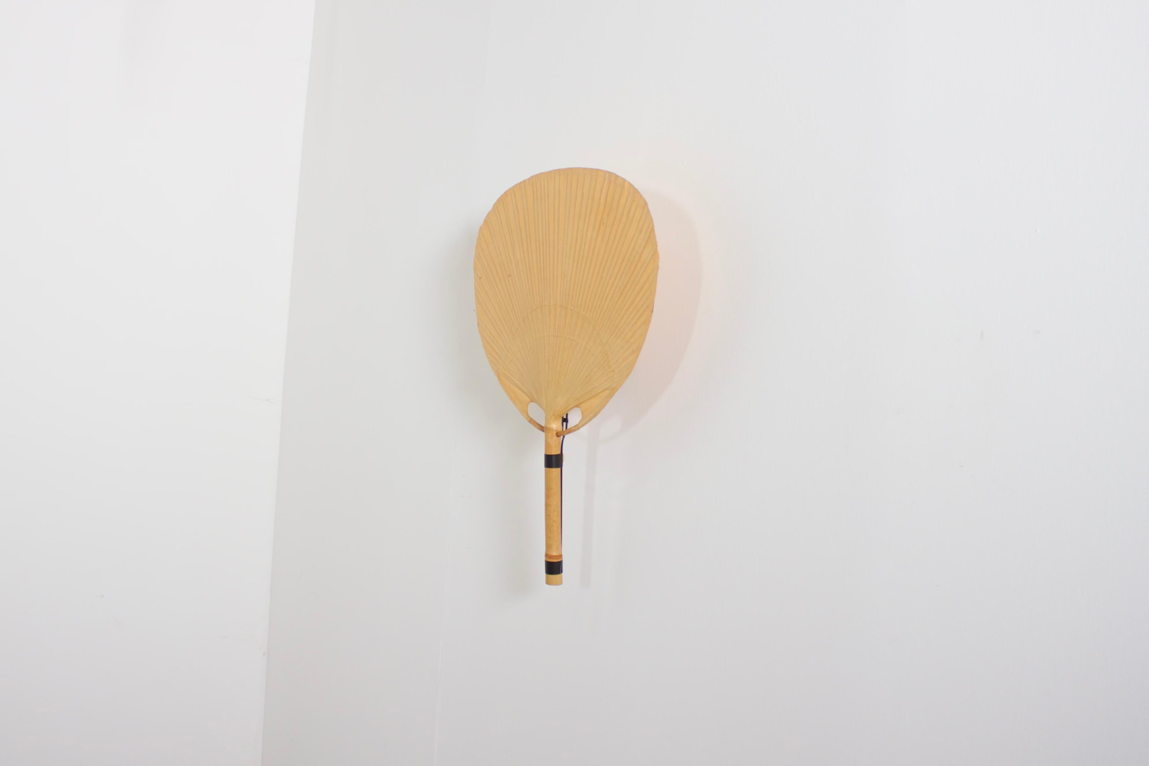 Uchiwa fan wall lamp by Ingo Maurer in very good condition. 

Designed by Ingo Maurer for M design, Germany. 

This lamp was handmade in 1977 from bamboo, wicker and Japanese rice paper. 

It is very fragile and therefor very hard to find in good