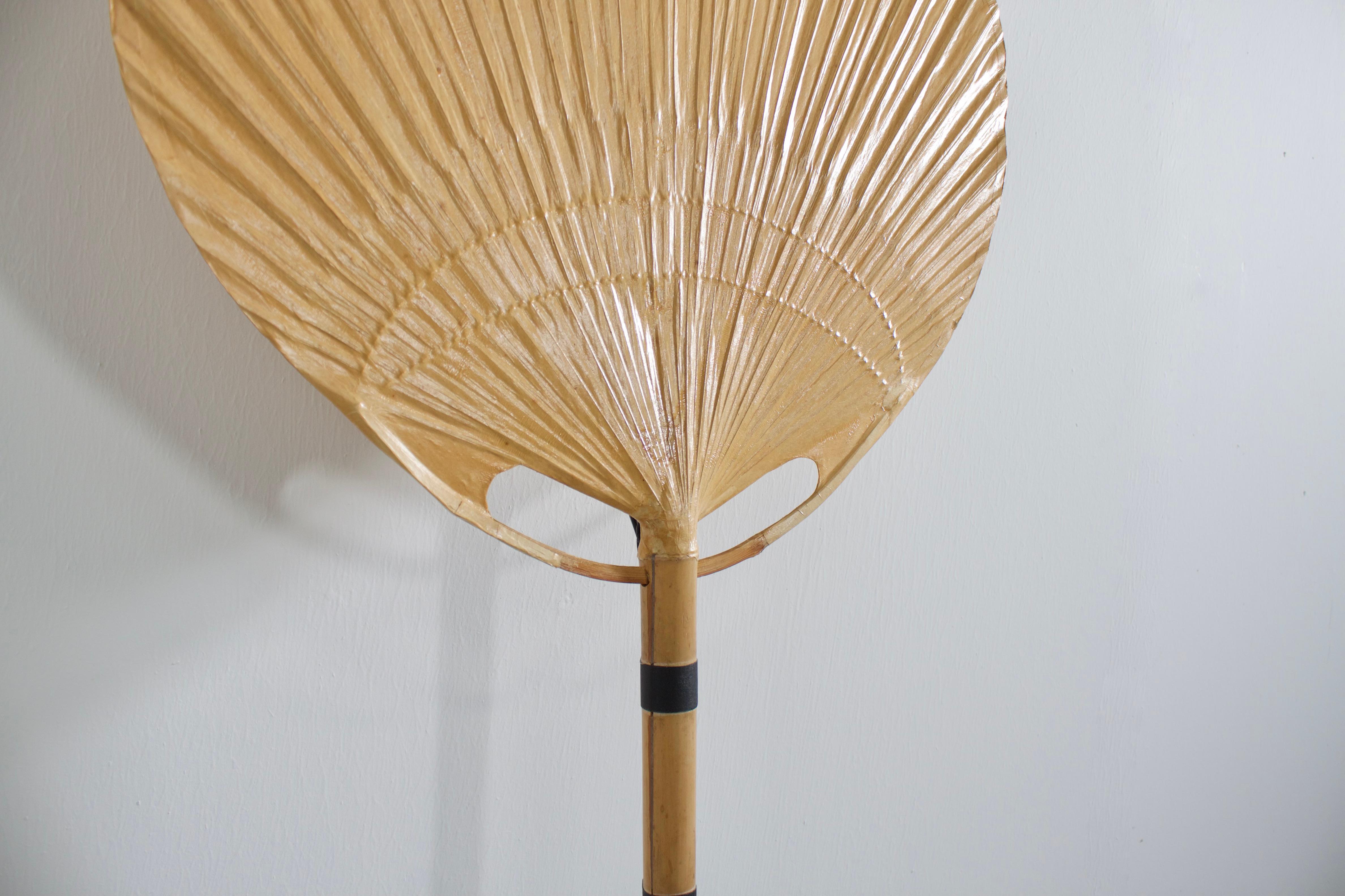 Uchiwa fan wall lamp by Ingo Maurer in very good condition. 

Designed by Ingo Maurer for M design, Germany. 

This lamp was handmade in 1977 from bamboo, wicker and Japanese rice paper. 

It is very fragile and therefor very hard to find in good