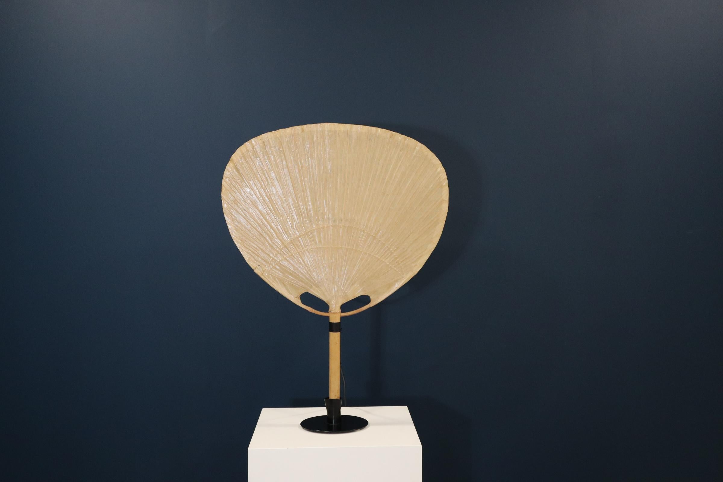 Uchiwa III wall & table lamp by Ingo Maurer, 1970s

This stunning Uchiwa lamp was designed by Ingo Maurer, in Germany, 1973. It is the larger size from the table lamp series with its rare and original metal holder, the Uchiwa can also be used as a