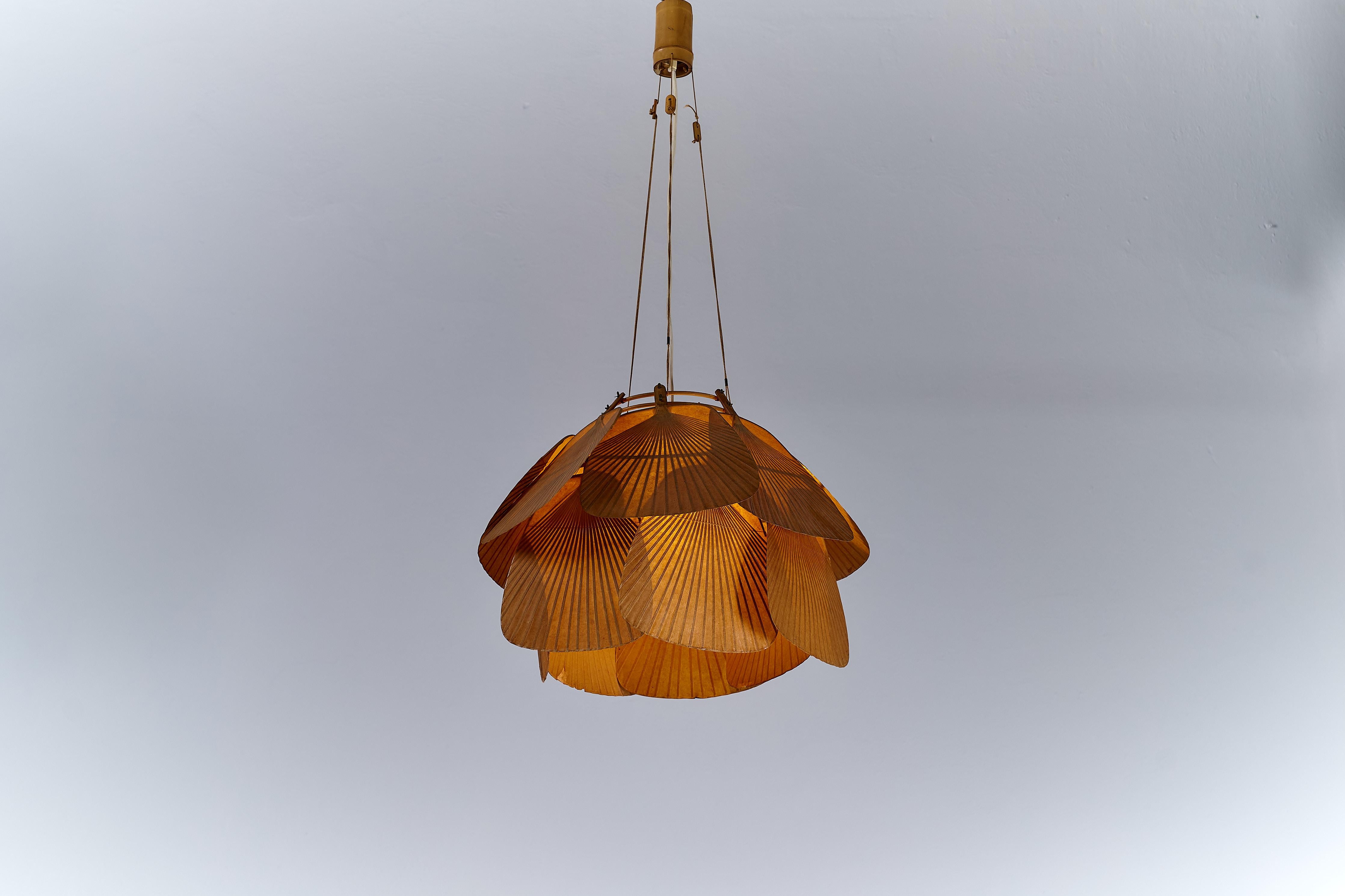 Mélange frappant de tradition et de design d'avant-garde, la lampe suspendue Uchiwa d'Ingo Maurer pour Design/One illustre l'exploration artistique des années 1970. Composé de quatorze ventilateurs fabriqués à partir de bambou et de papier de riz,