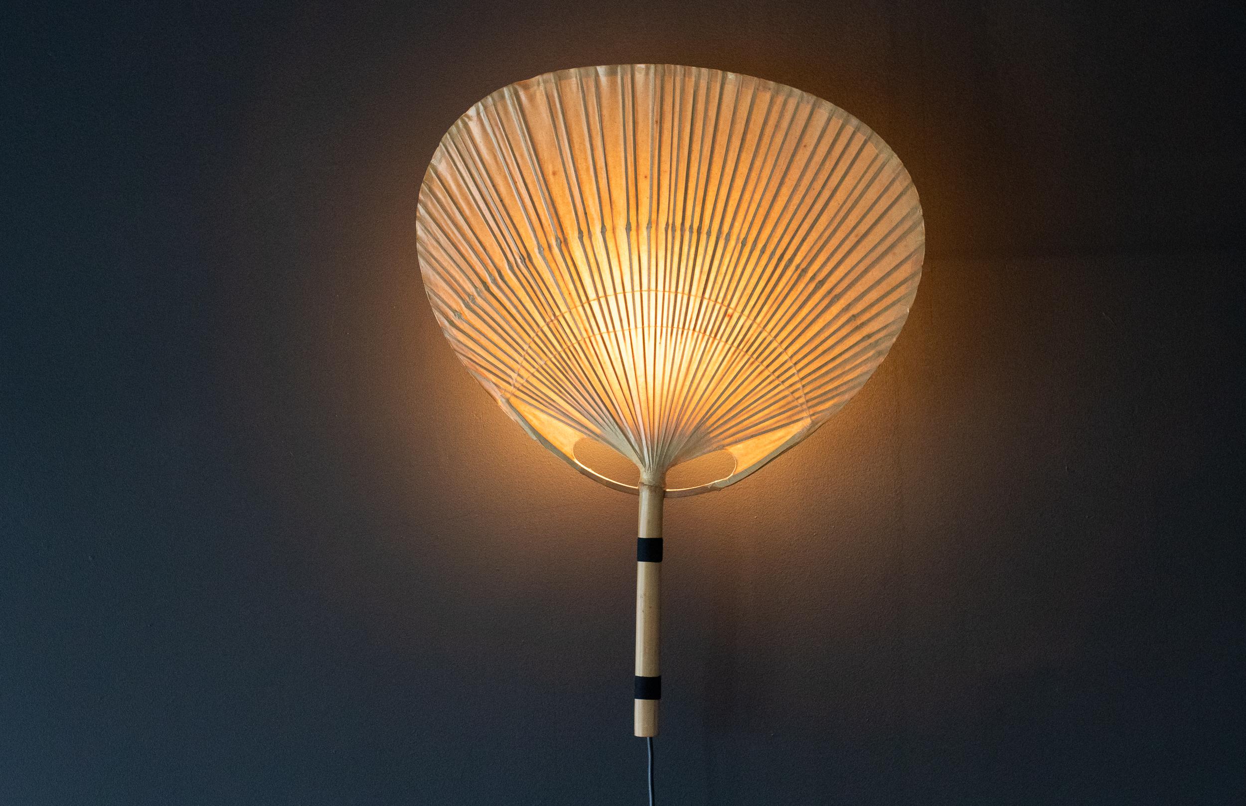 An “Uchiwa” wall light by Ingo Maurer (1932 to 2019) for M design, Germany, 1970s. 
Beautiful understated design composed of rice paper and bamboo, which gives a beautifully warm and diffuse glow. The light is in wonderful all original vintage