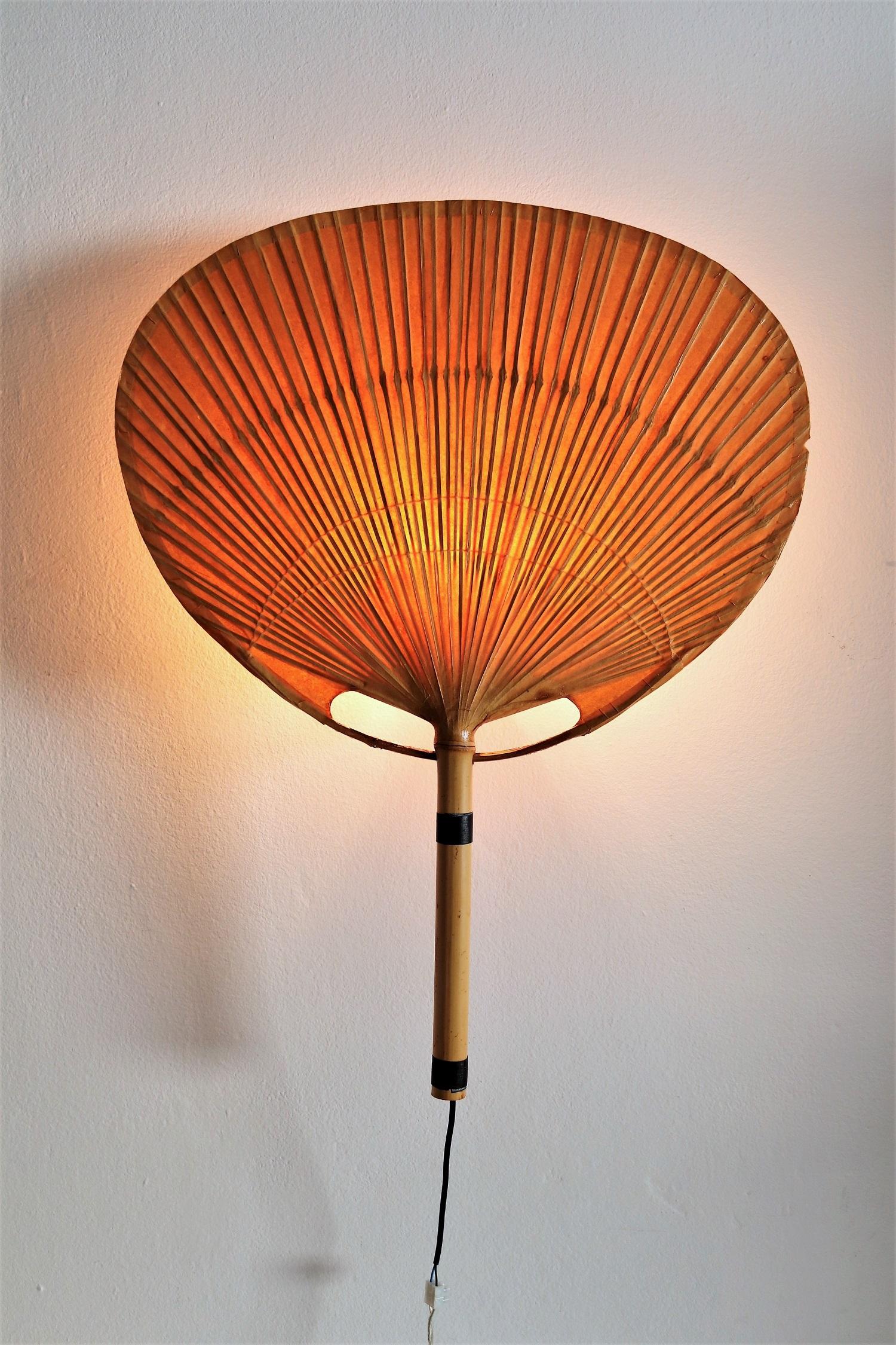 One piece of big vintage Uchiwa fan lamp with metal holder for wall hanging,
Designed from Ingo Maurer, Germany in 1973.
The light is made of natural bamboo and Japanese rice paper, and therefore natural signs of age are normal.
The metal holder