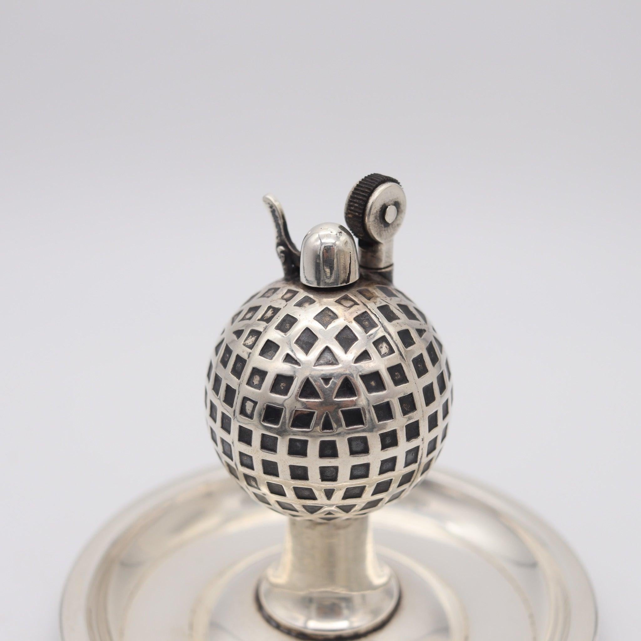 Cendrier de bureau en forme de balle de golf Udall & Ballou.

Il s'agit d'un magnifique briquet de table à pétrole créé à New York durant la période art-déco par Udall &New, en 1920. Le modèle a été conçu comme une combinaison d'un cendrier et d'un