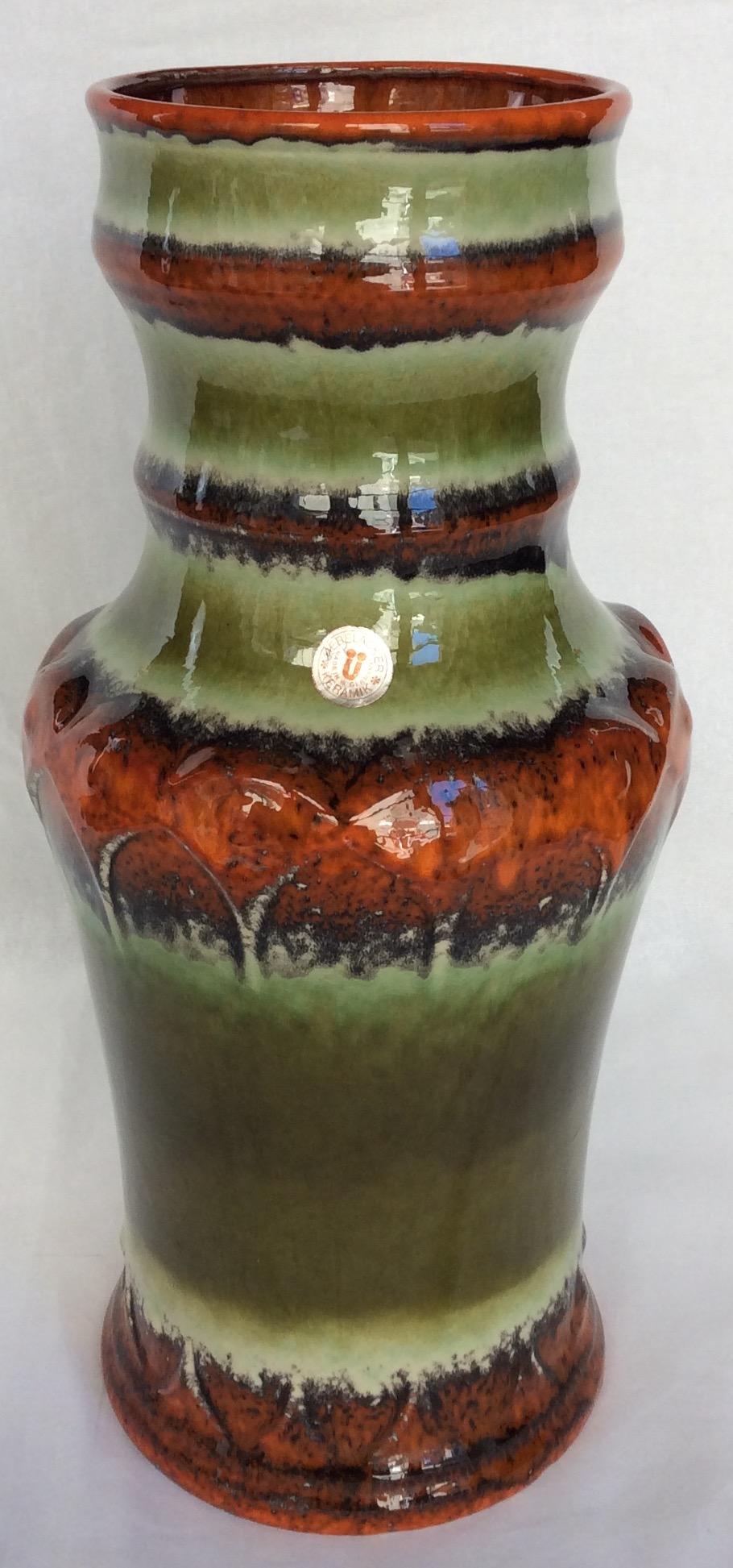 Diese hohe Sammlervase aus der Mitte des Jahrhunderts wurde um 1965 von dem bekannten westdeutschen Keramikhersteller Uebelacker Keramik hergestellt. Die Vase hat wunderschöne grüne, orange, beige und braune Farbtöne und ist perfekt glasiert. Dieses