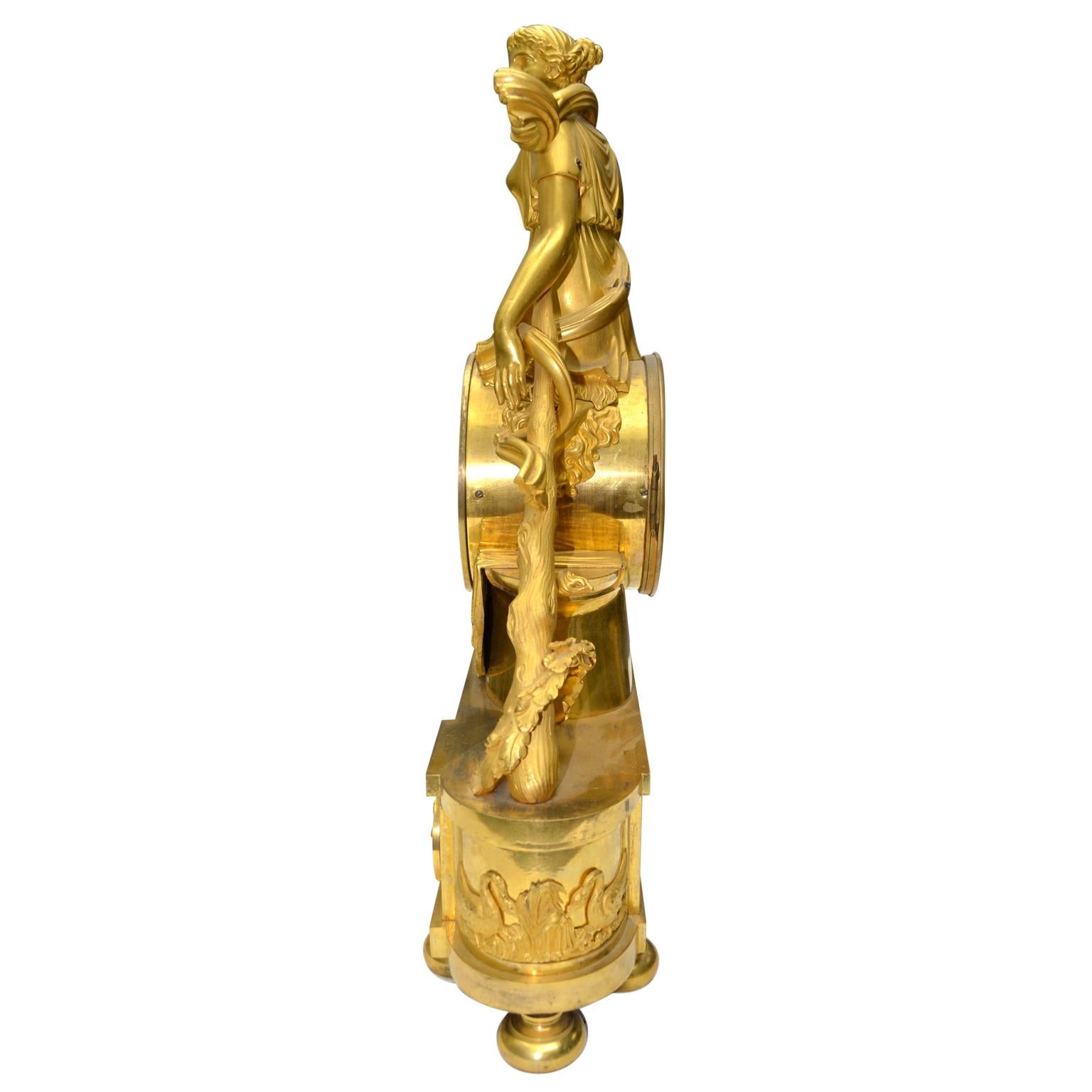 Doré  Horloge Empire française en bronze doré représentant l'omphale de la reine lydienne en vente