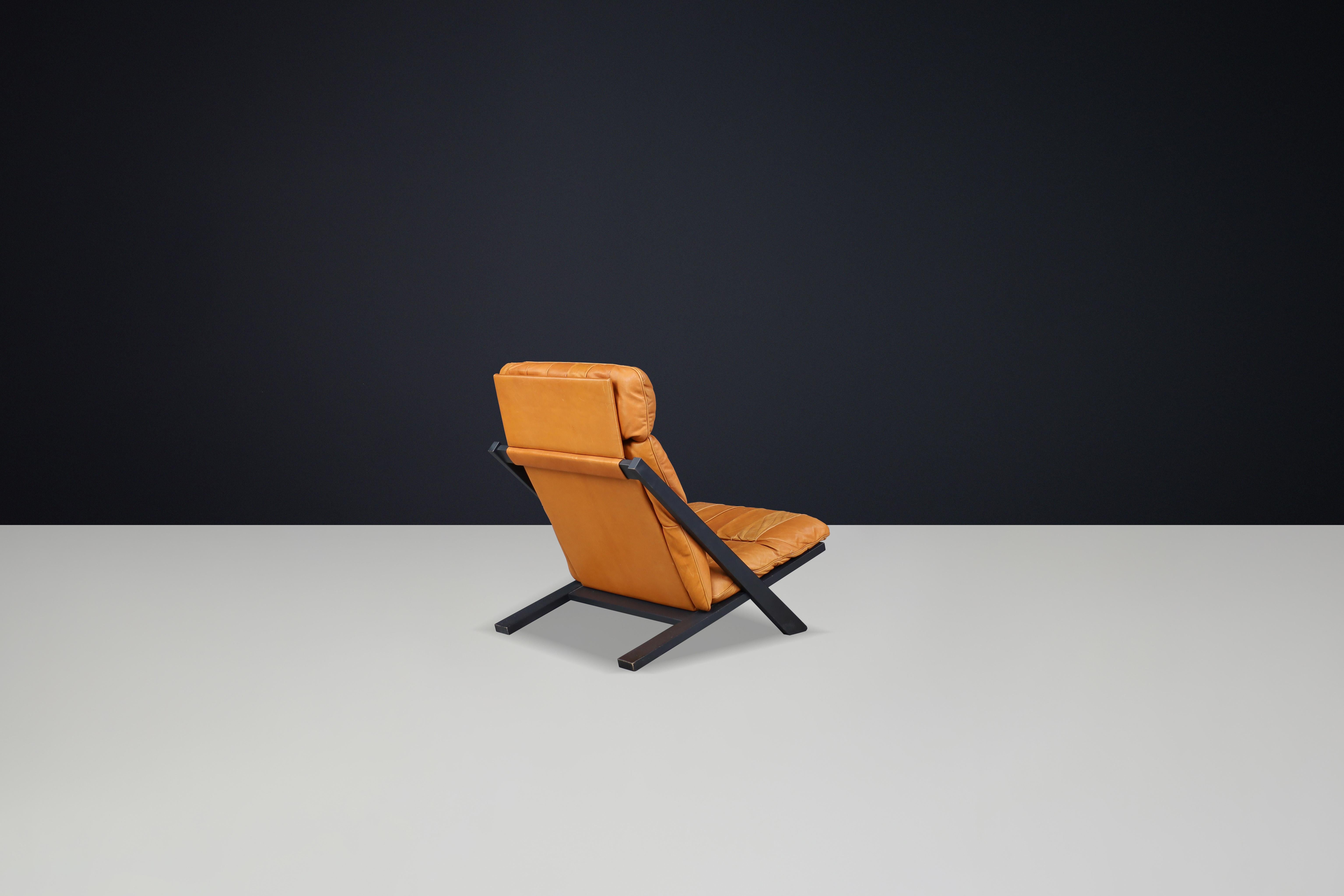 20th Century Ueli Berger for De Sede, lounge chair, wood, Cognac leather, Switzerland, 1970s. For Sale