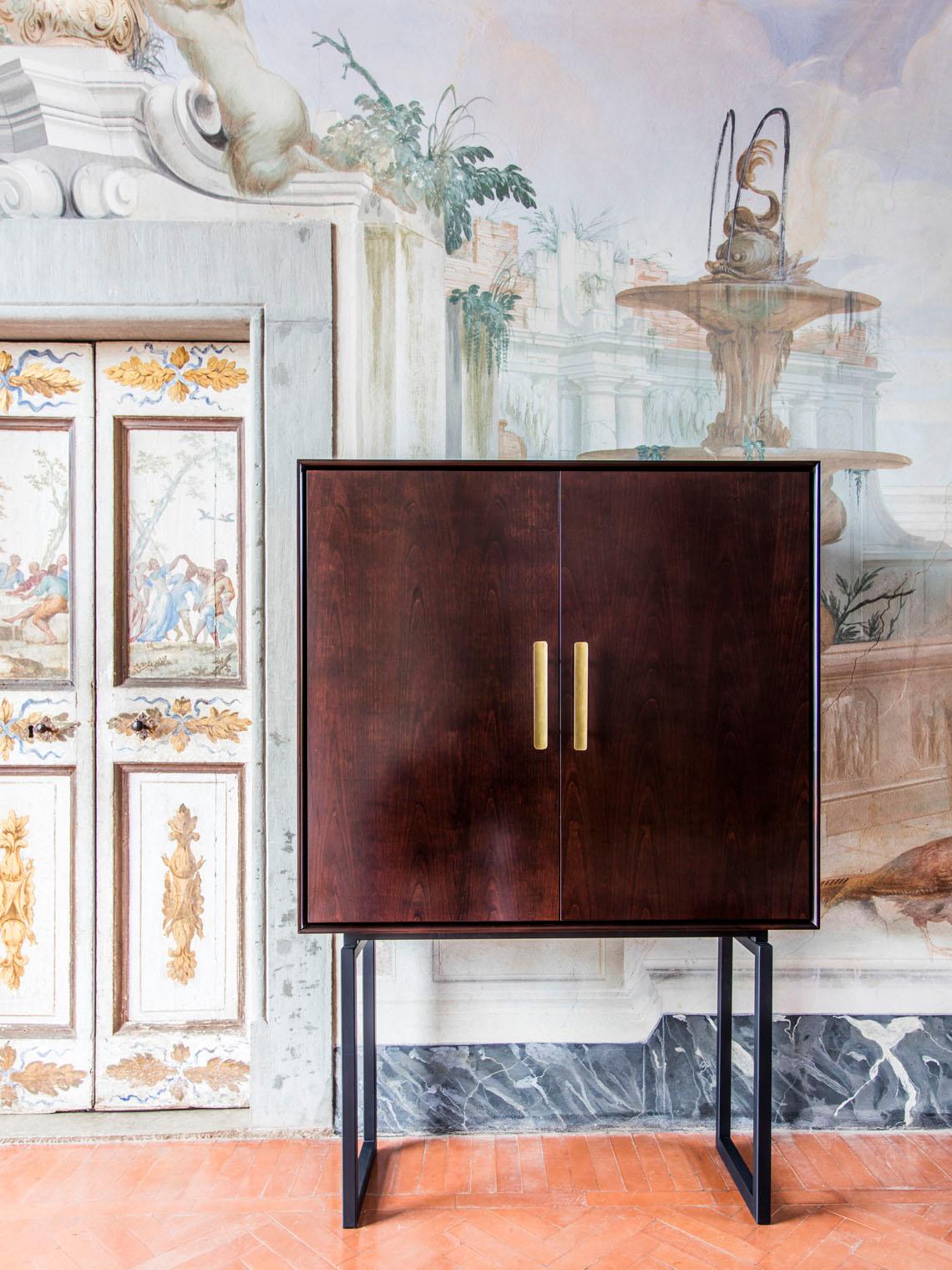 Our classical bar cabinet evokes the times when a drink before dinner was common practice. Behind the cherry wood doors opens an elegant interior with glass shelves and a antique mirror back. 

Available in different woods or varnished in a color