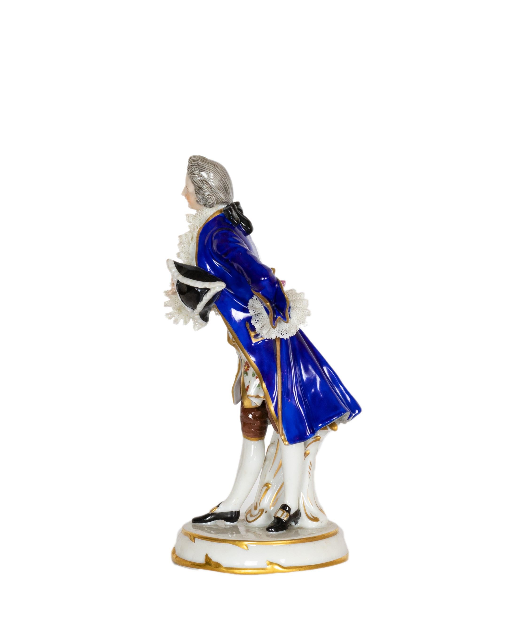 
A porcelain figurine made by Steingutfabrik J. Uffrecht in Dresden, featuring King Luis XIV attired in formal, royal blue, and bearing a crown, with the mark «A J».