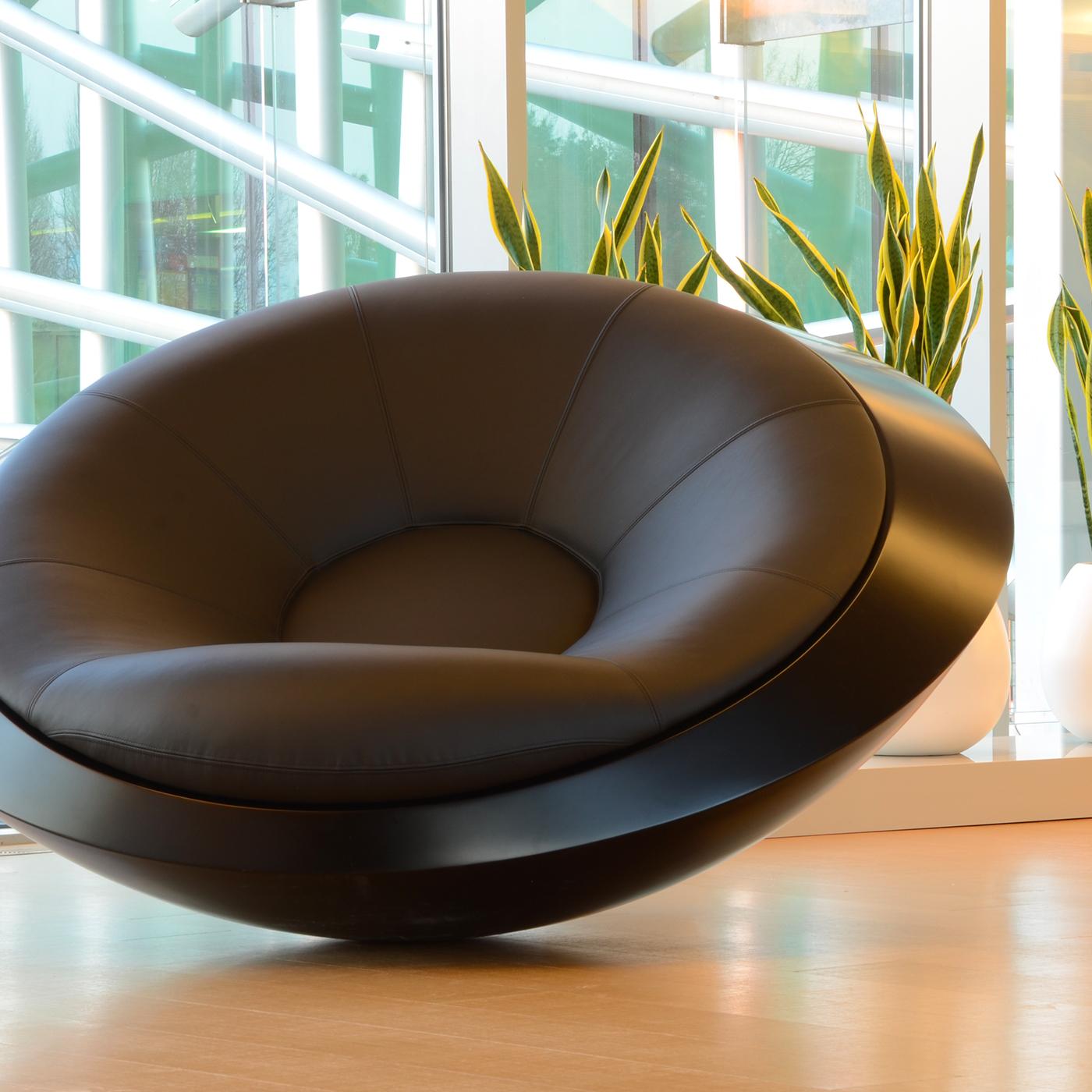 Uniquely handcrafted to order, this exquisitely designed armchair boasts a minimal and contemporary allure. Entirely made in black, it exudes elegance and sophistication. The large and comfortable cushion that can accommodate two people is filled