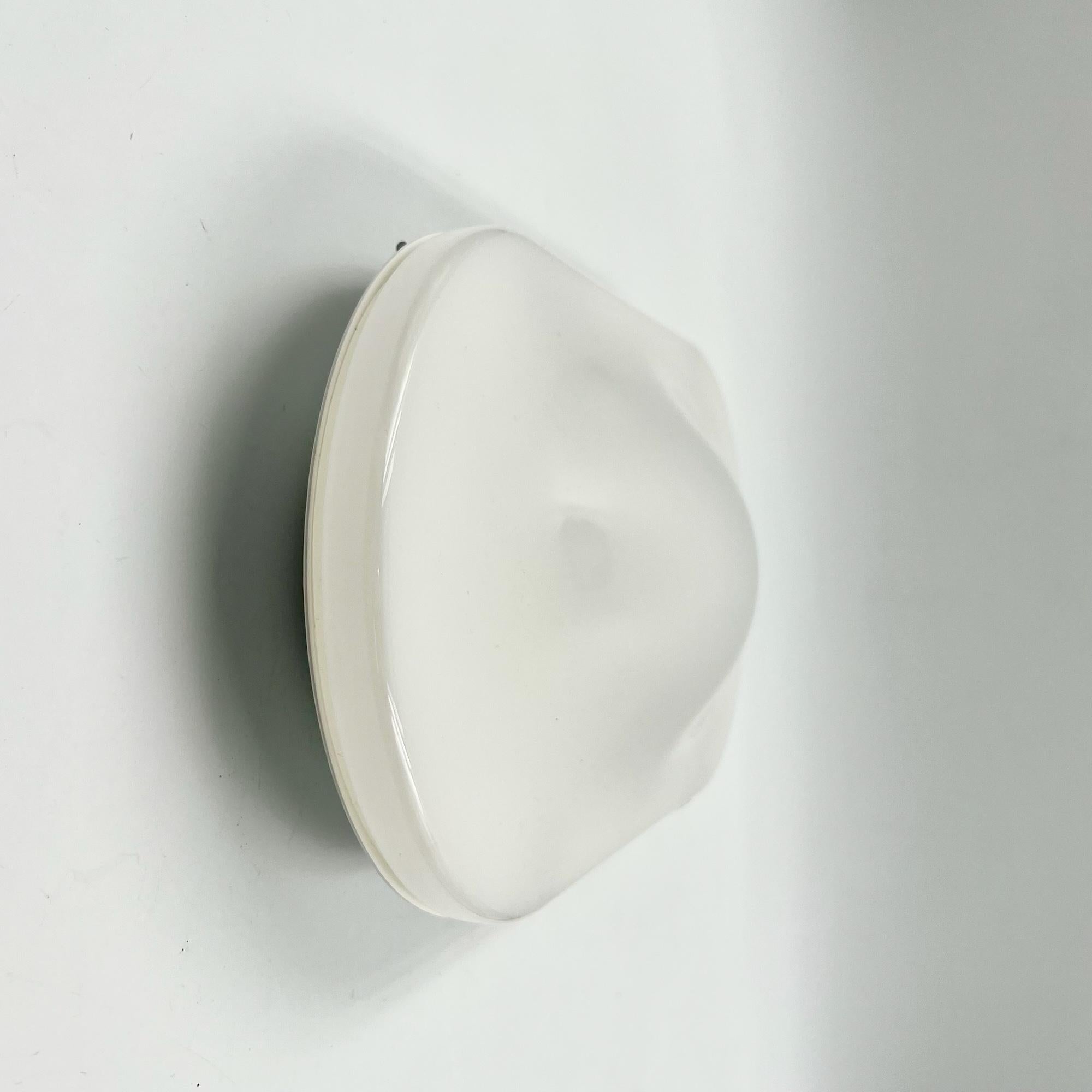 Illuminate your space with the iconic UFO lamp, a vintage masterpiece from the 1980s produced by iGuzzini in Italy. This versatile lamp, suitable for both wall and ceiling mounting (flush mount), embodies minimalist style with its distinctive shape