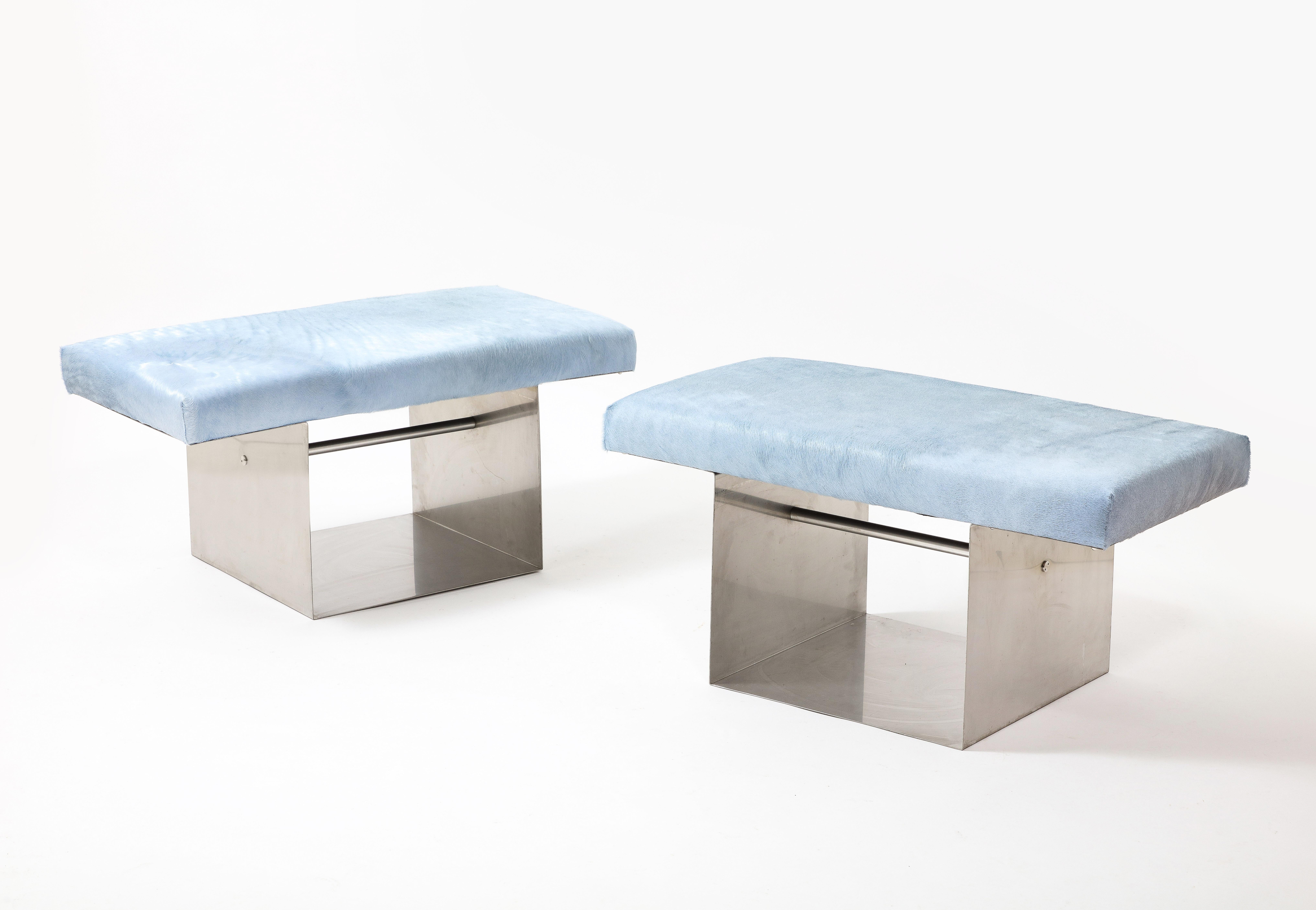 Bent stainless steel benches with light blue hair on hide upholstery.
