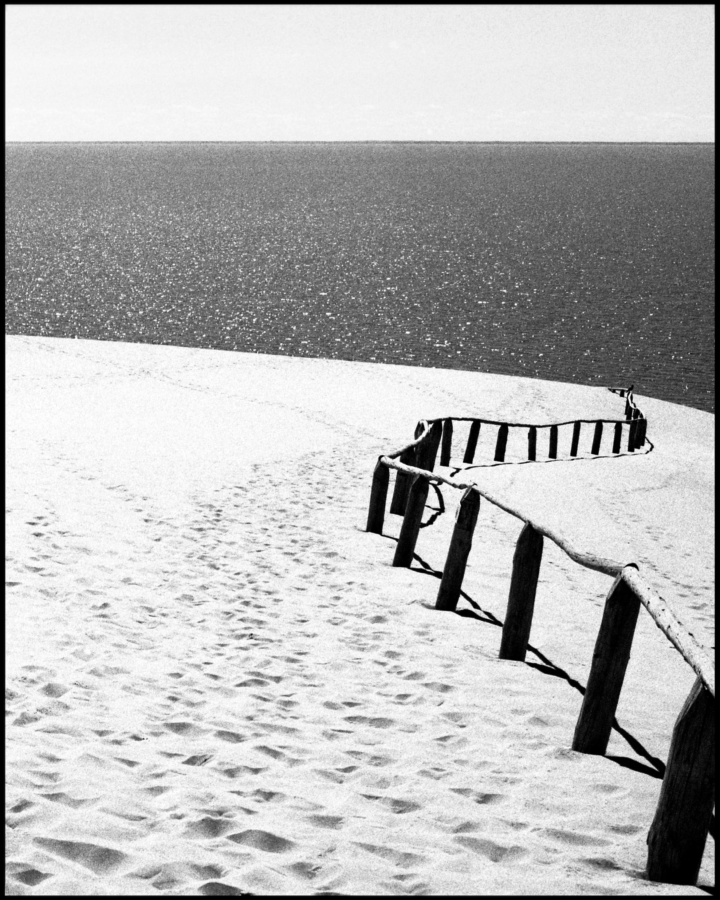 Ugne Pouwell Black and White Photograph – Nida – Schwarz-Weiß- Analogue-Fotografie von Sandünen und Baltischem Meer