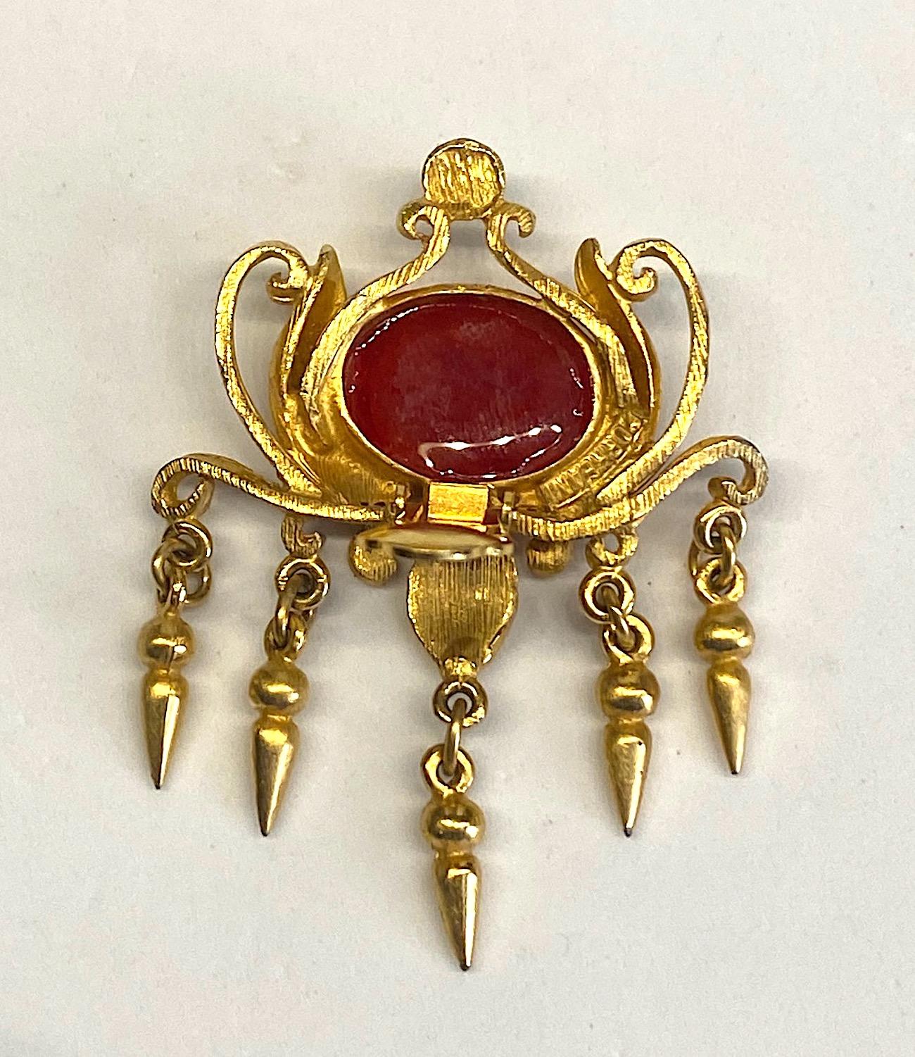 An intricate statement pair of 1980s earring by Italian jewelry designer Ugo Correani. Satin gold finish with large 13 x 18 mm faux red ruby cabochon. The earrings are meticulously crafted with hand soldered curly wires on a cast center piece with