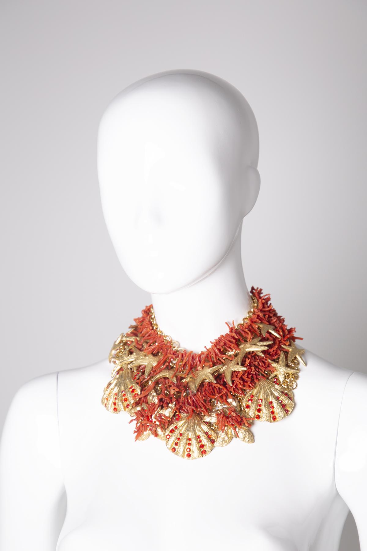 Majestic necklace designed by Ugo Correani for the Gianni Versace brand, Capri series from 1980s.
The necklace is made with a gold metal necklace. The necklace is embellished with coral elements that surround the whole necklace. What makes it
