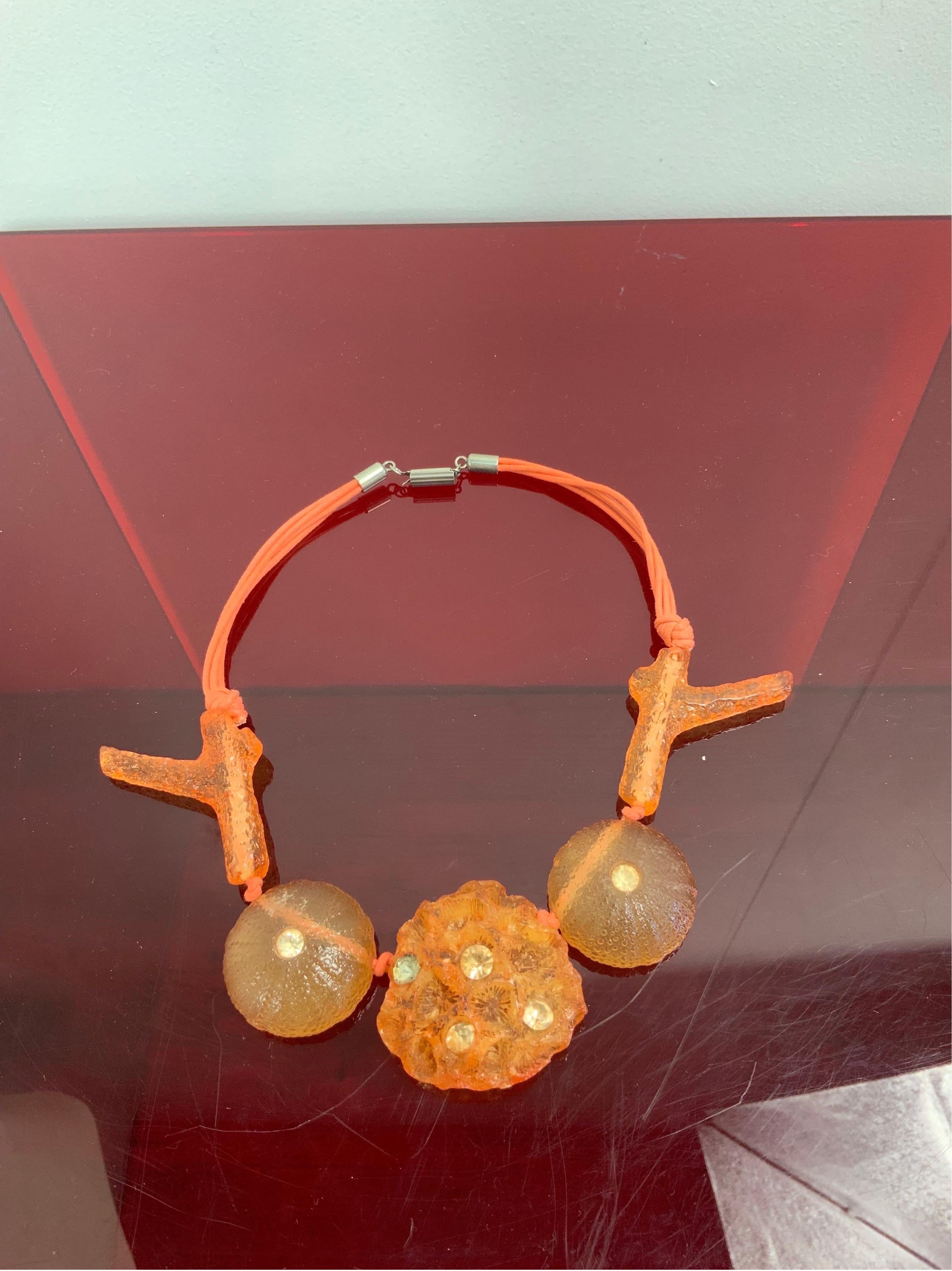 Ugo Correani-Halskette.
Berühmter italienischer Schmuckdesigner.
Thema Marine
Aus orangefarbenem Harz und Perlen.
23 cm lang.
Es ist in gutem Allgemeinzustand und weist normale Gebrauchsspuren auf.