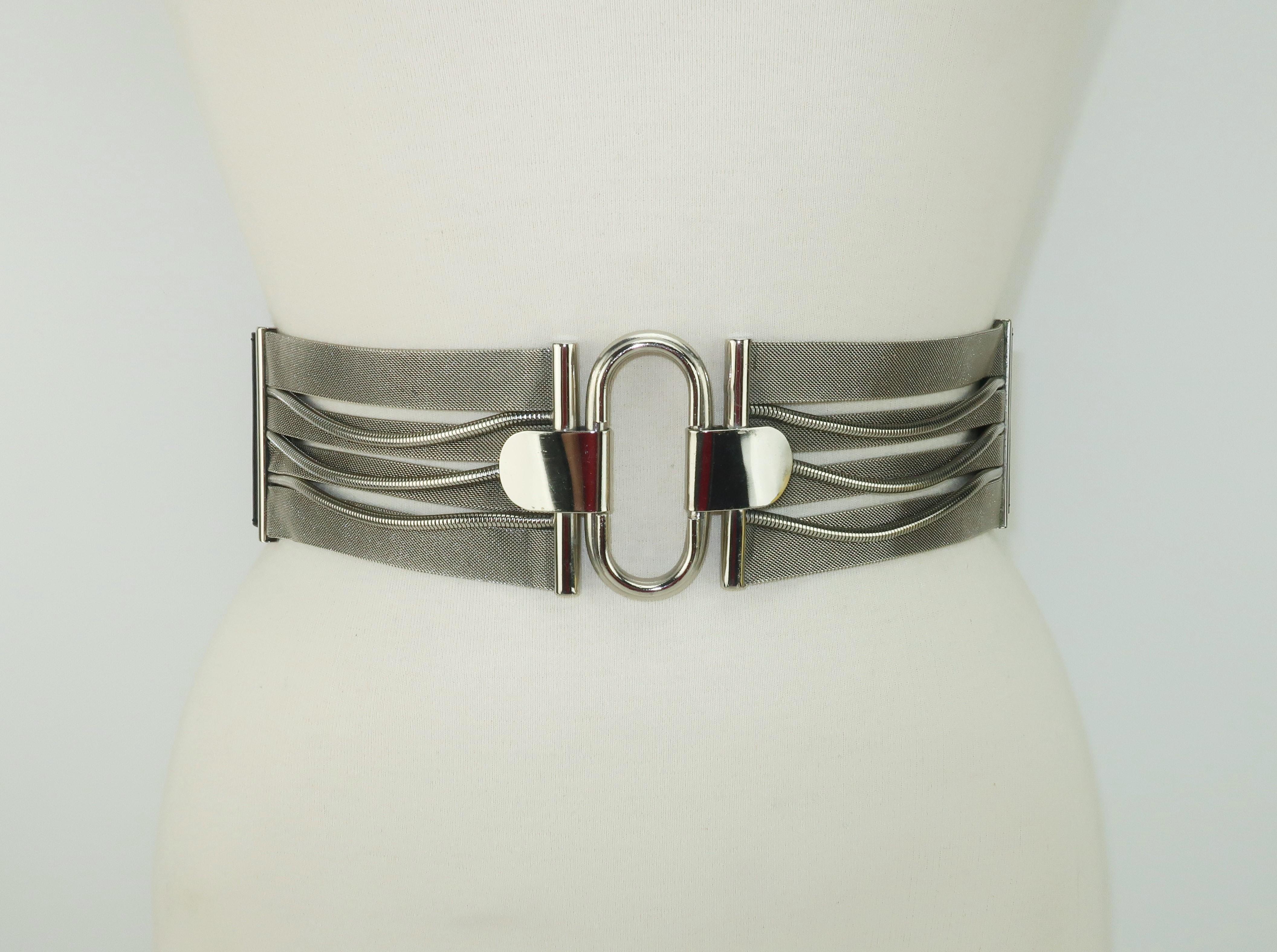 Italian jewelry designer, Ugo Correani, created this black leather belt for Genny in the late 1970's during Gianni Versace's tenure as fashion director. The belt incorporates silver mesh accented by a paperclip style centerpiece and serpentine