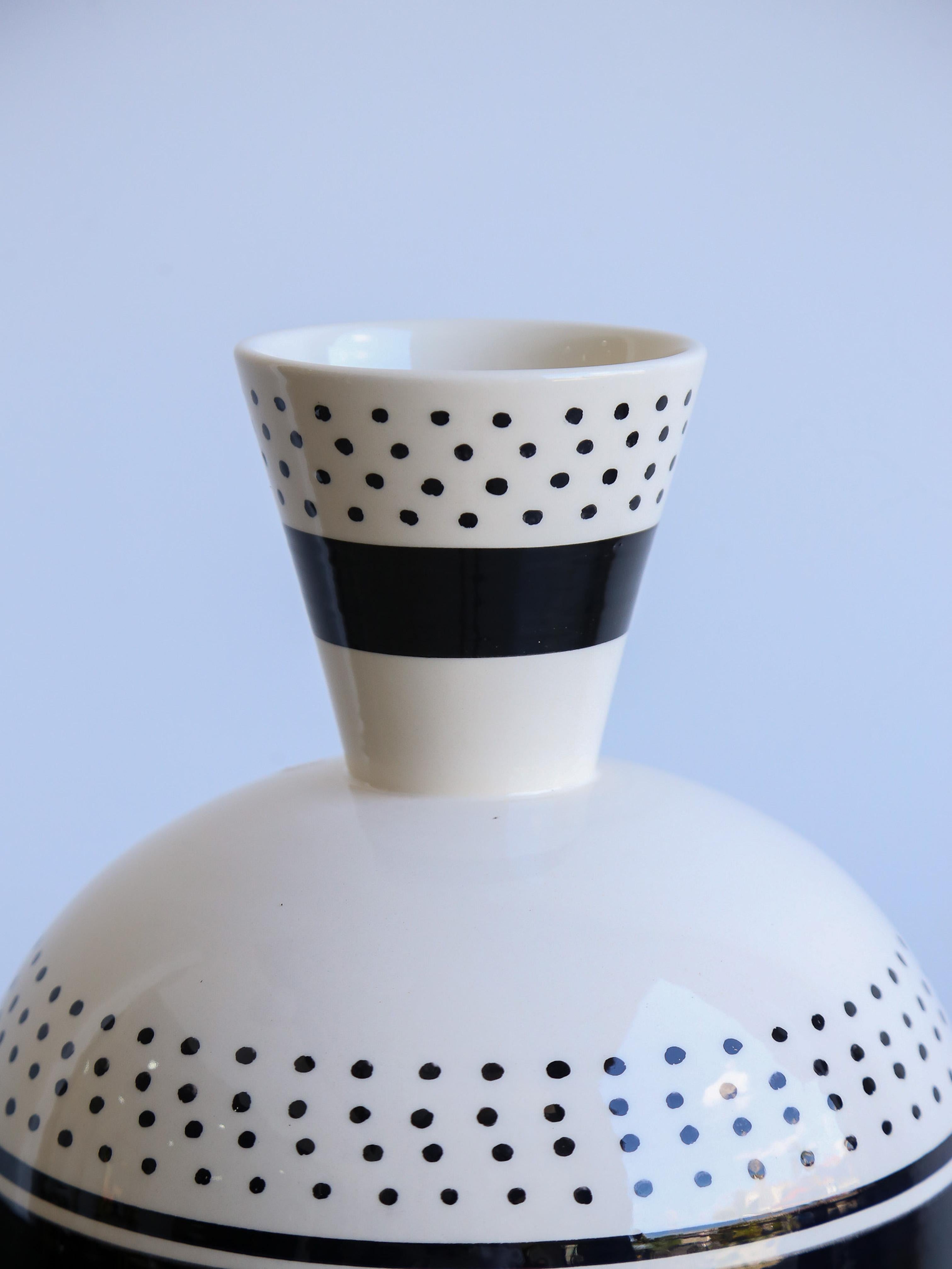 Conical and spheroidal vases play with lines and crosses in a black and white ritual. Clay vase, hand thrown. White engobe finish decorated black with a transparent glaze.

Ugo La Pietra is an Italian artist, designer, and architect born in 1938.