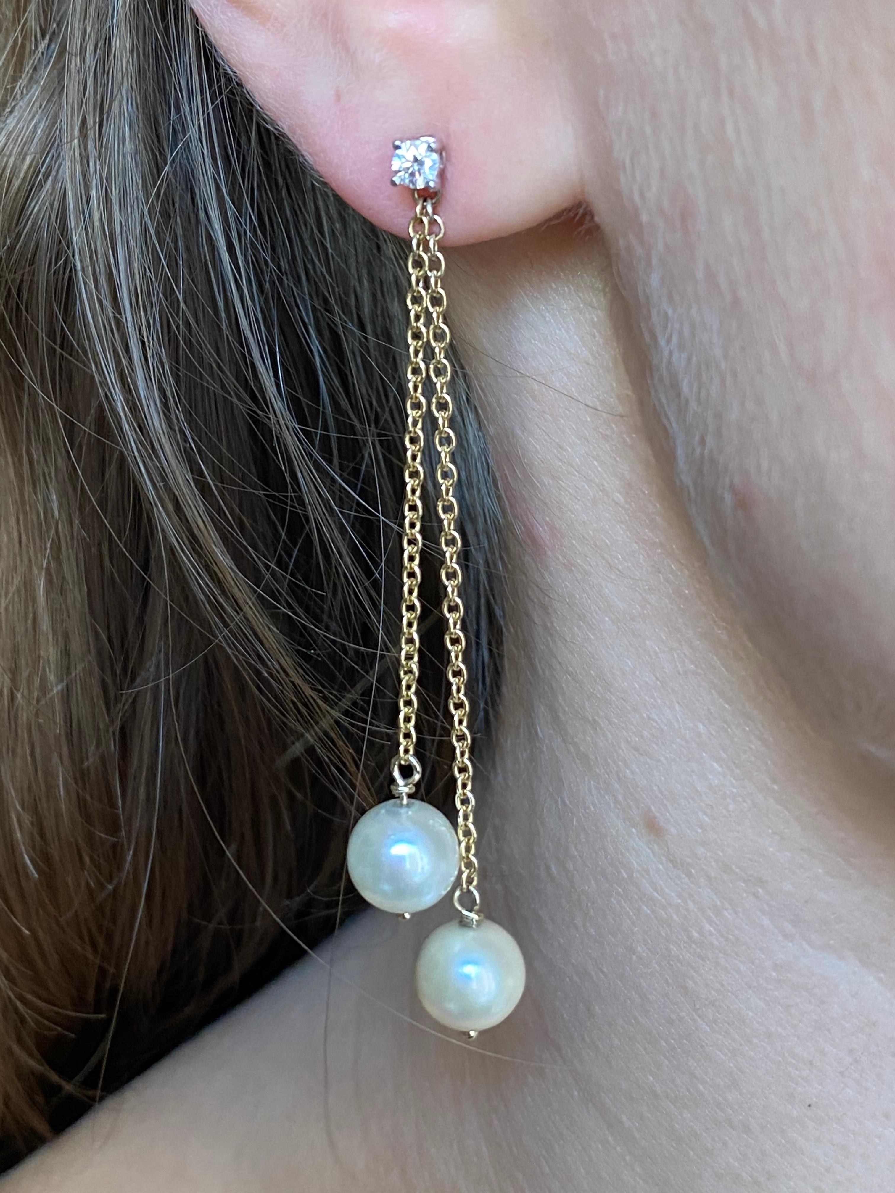 These amazing earrings are made with a 18 karats yellow gold little chain and 0,16 karats white diamonds, they're also embellished with two round white sea pearls.  
Pearls are believed to offer protection, as well as attract good luck and wealth.
A