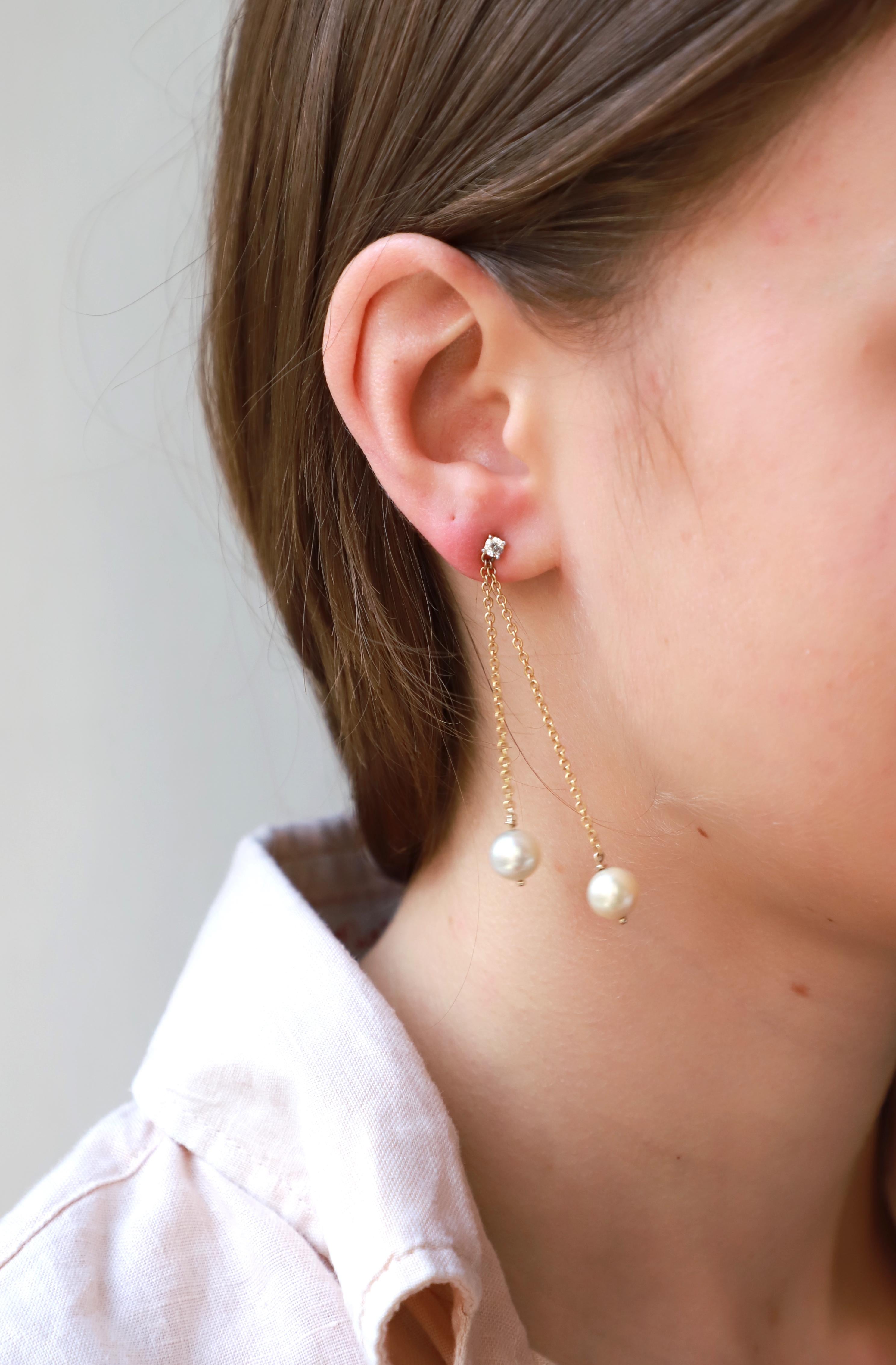 18Karat Gelbgold 0,16Karat Weißer Diamant Ohrringe mit modernem Design
Diese wunderschönen Ohrringe sind mit einem Kettchen aus 18 Karat Gelbgold und 0,16 Karat weißen Diamanten gefertigt und mit zwei runden Perlen verziert.  
Perlen sollen Schutz