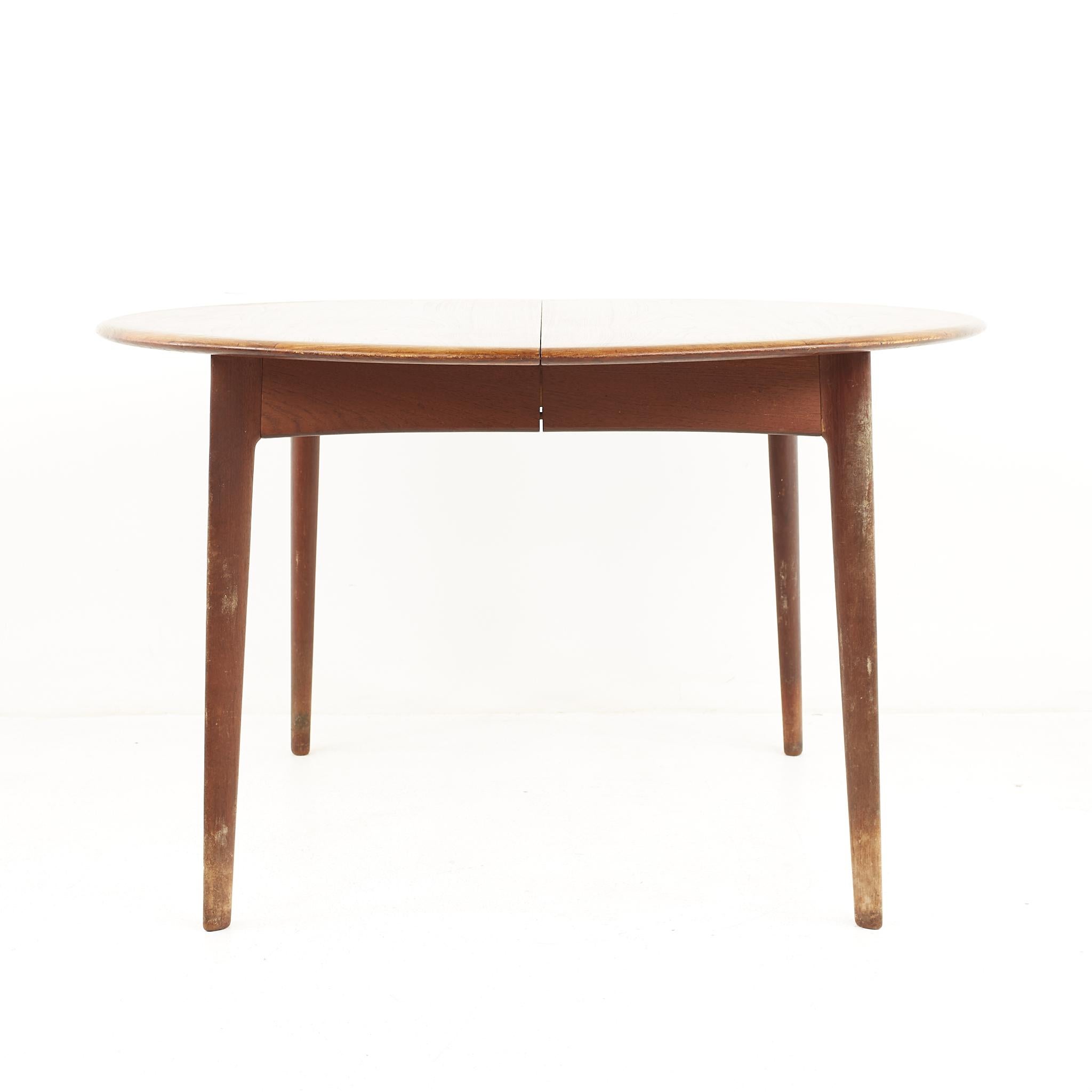 Uldum Mobelfabrik style mid century danish teak round dining table

The table measures: 48 wide x 48 deep x 28.5 high, with a chair clearance of 27.5 inches; each leaf is 24 inches wide, making a maximum table width of 96 inches when both leaves