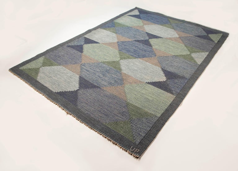 Ulla Parkdahl Swedish Flat-Weave Rug, Signed UP, Sweden, 1960s

This is an excellent example of Ulla Parkdal as a master weaver of exquisite Swedish rug designs. With a distinctly midcentury geometric design, the Green and blue angles are lined with